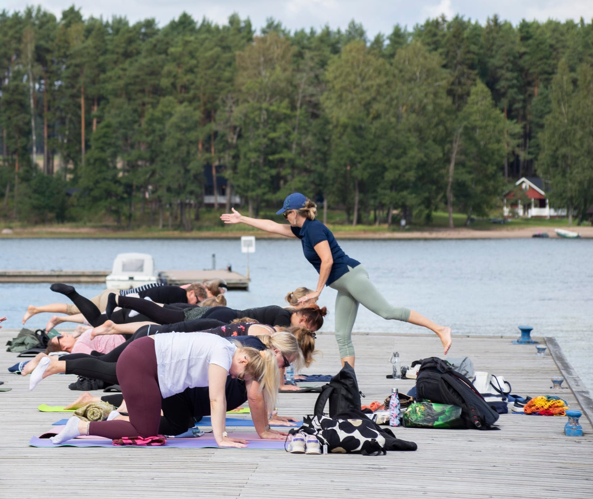 Yoga teacher giving instructions for yoga students on the pier.
