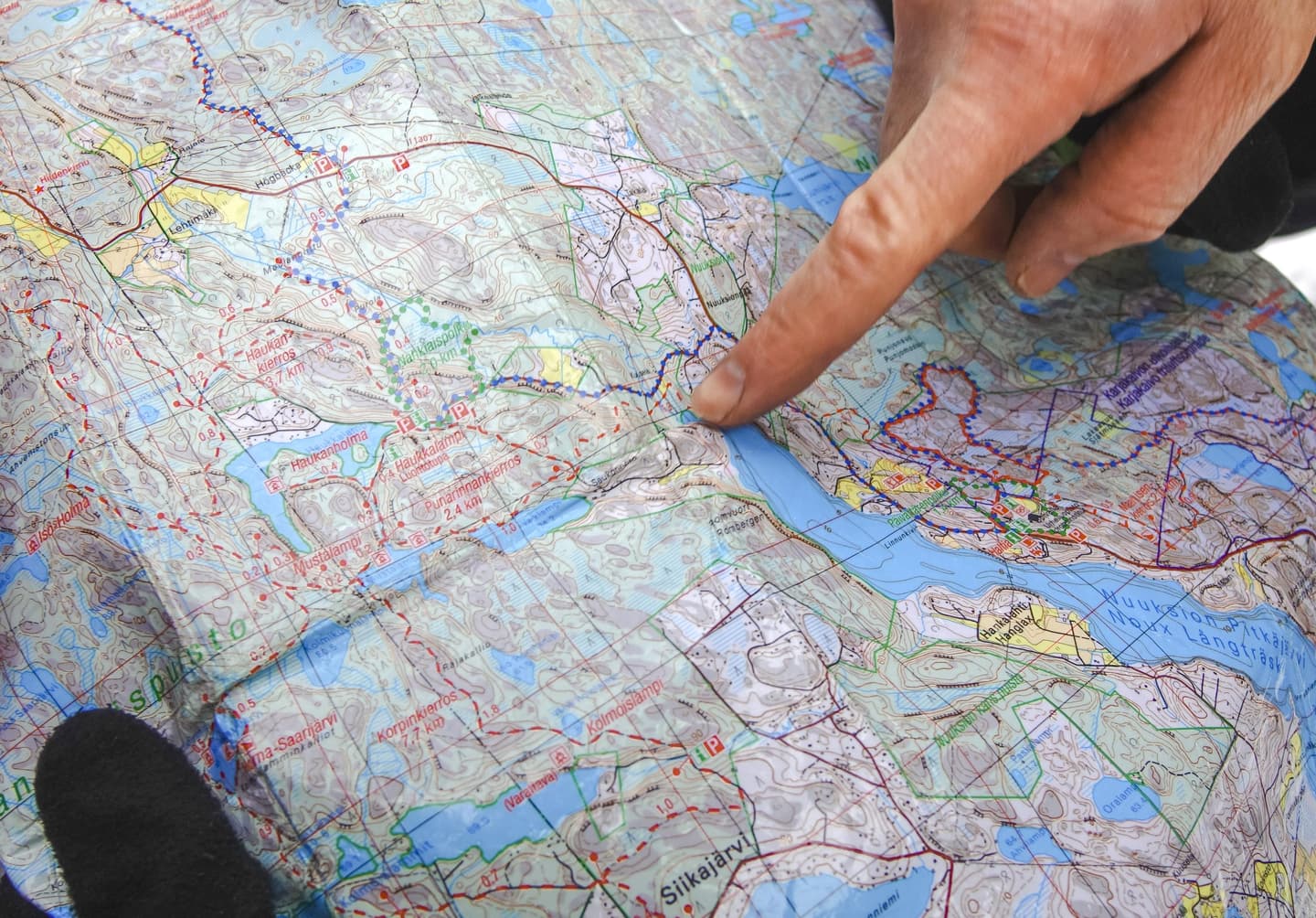 A finger is pointing to a spot on the outdoor map.