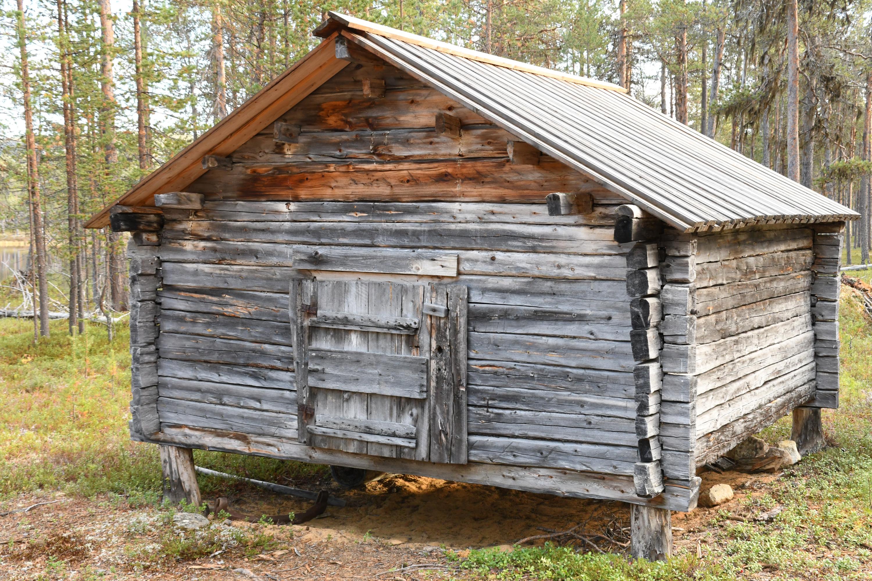 Kantojen päälle rakennettu puinen aitta.