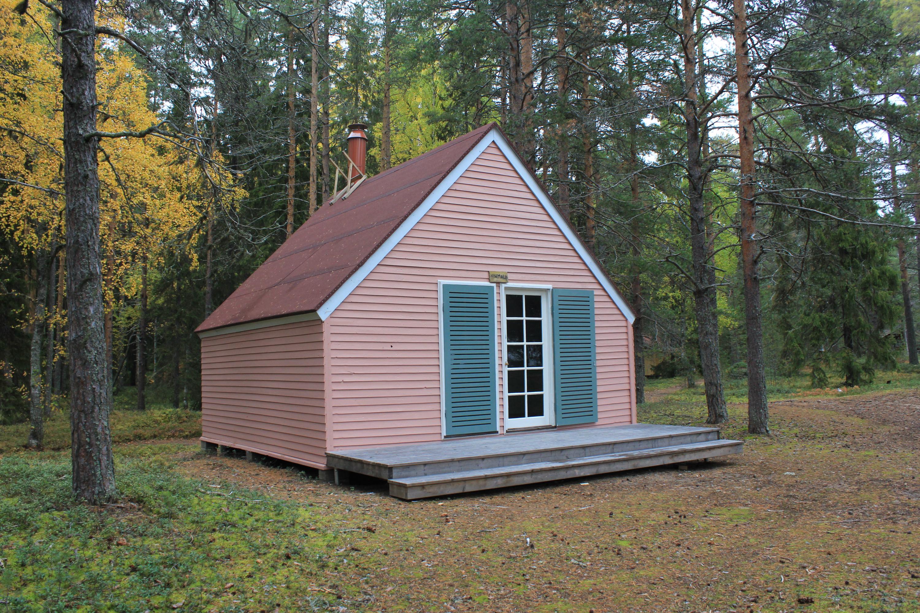A rental cabin in the middle, with a pine forest in the background.