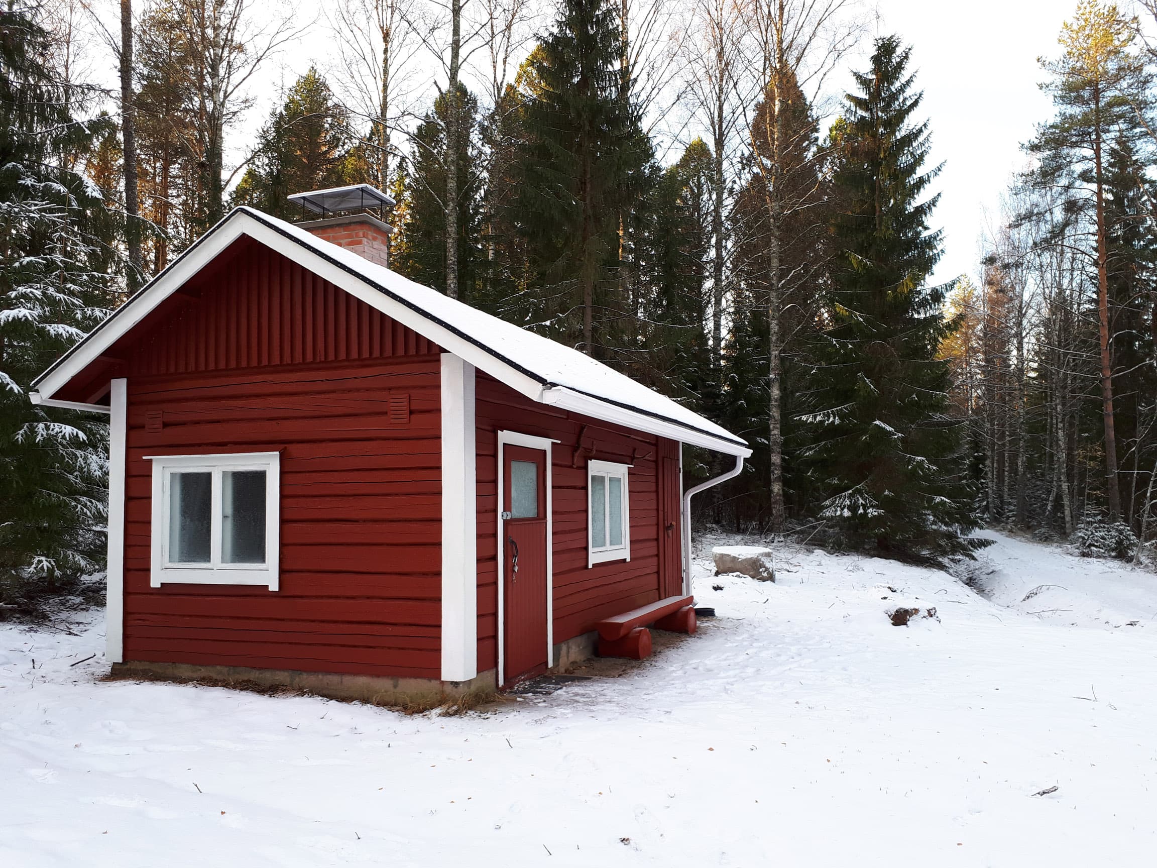 Punainen tupa. Taustalla metsää.