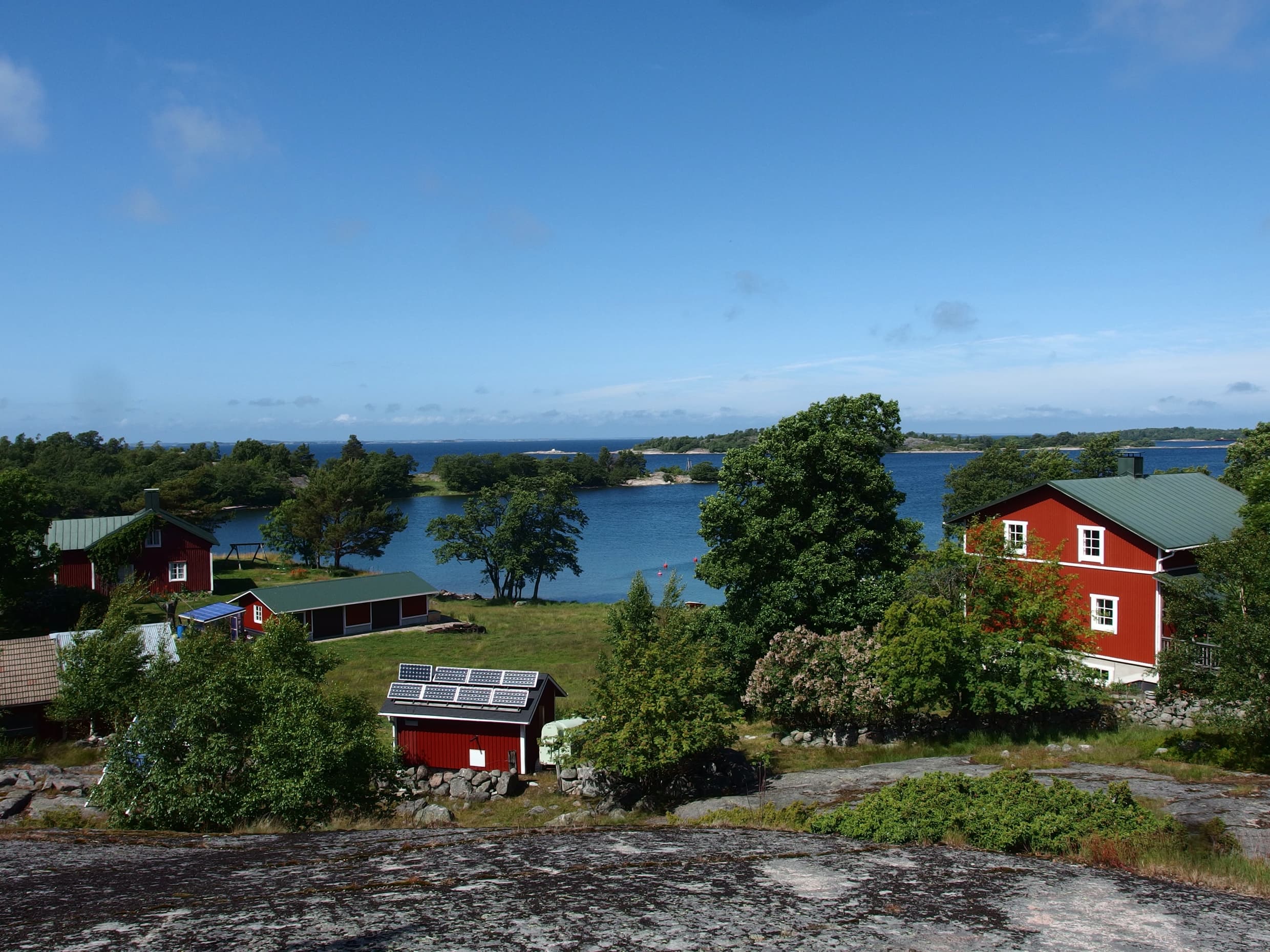 Tunnhamnin kylä, jossa on punaisia taloja ja taustalla meri.