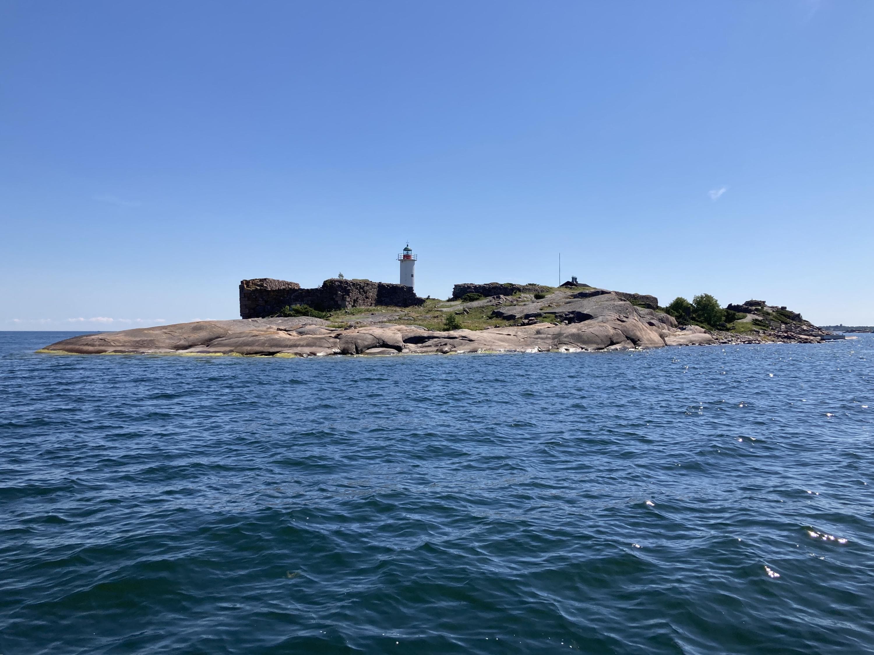 Ön sedd från havet. På ön finns ett fästningsruin och en fyr.