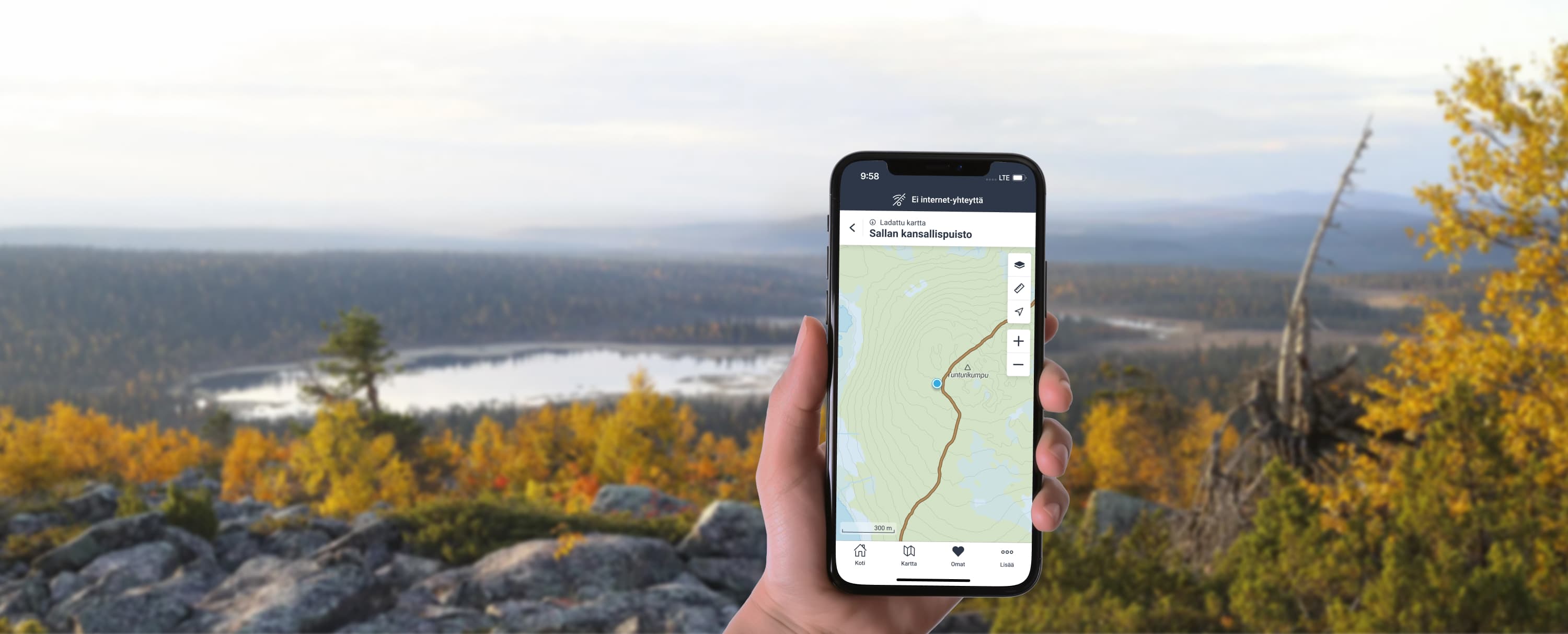 Käsi, jossa on kännykkä ja siinä näkyy Luontoon-sovellus. Taustalla tunturimaisemaa.