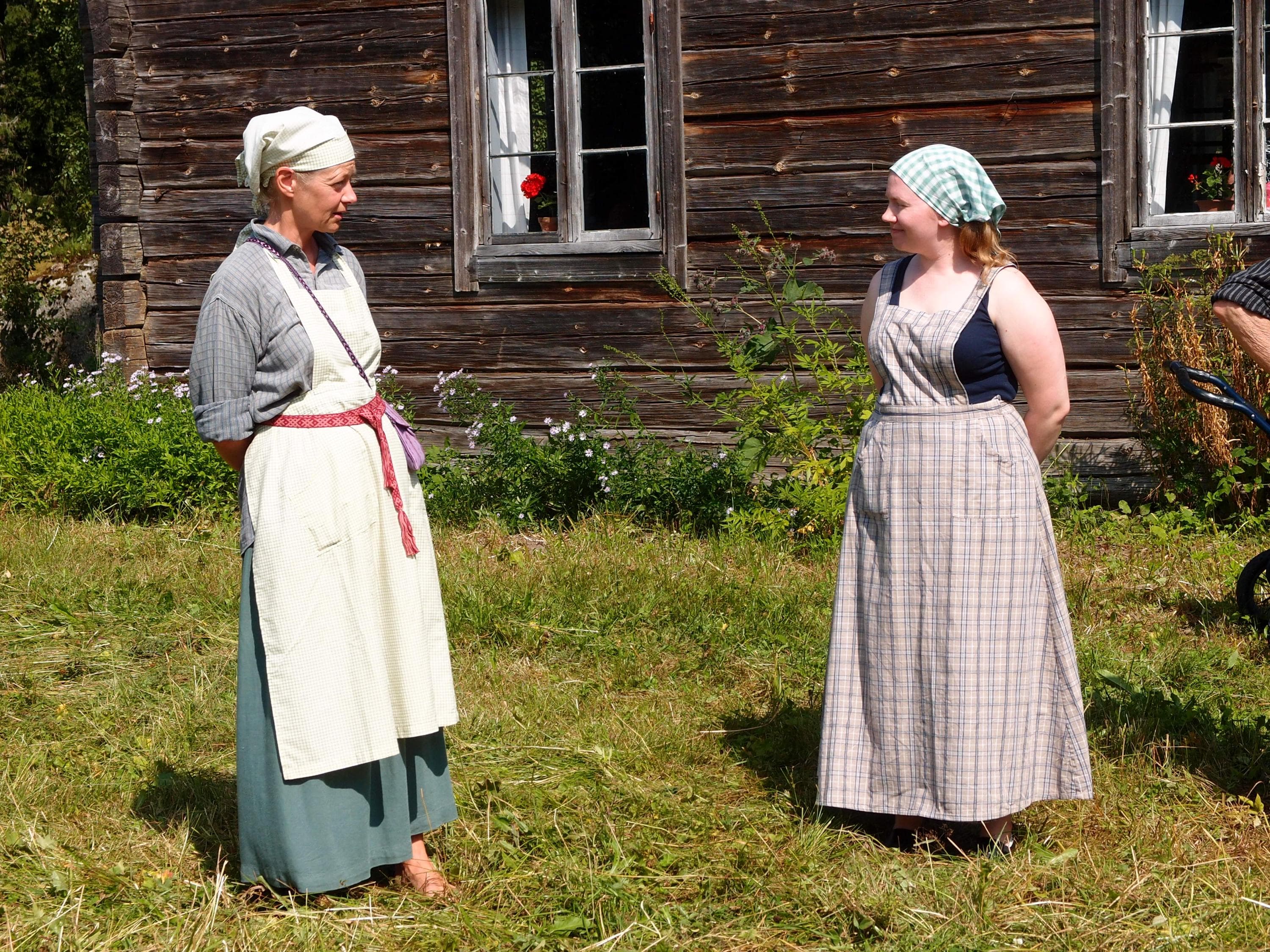 Image: Jere Ekosaari People dressed in old-time costumes in front of a log building.