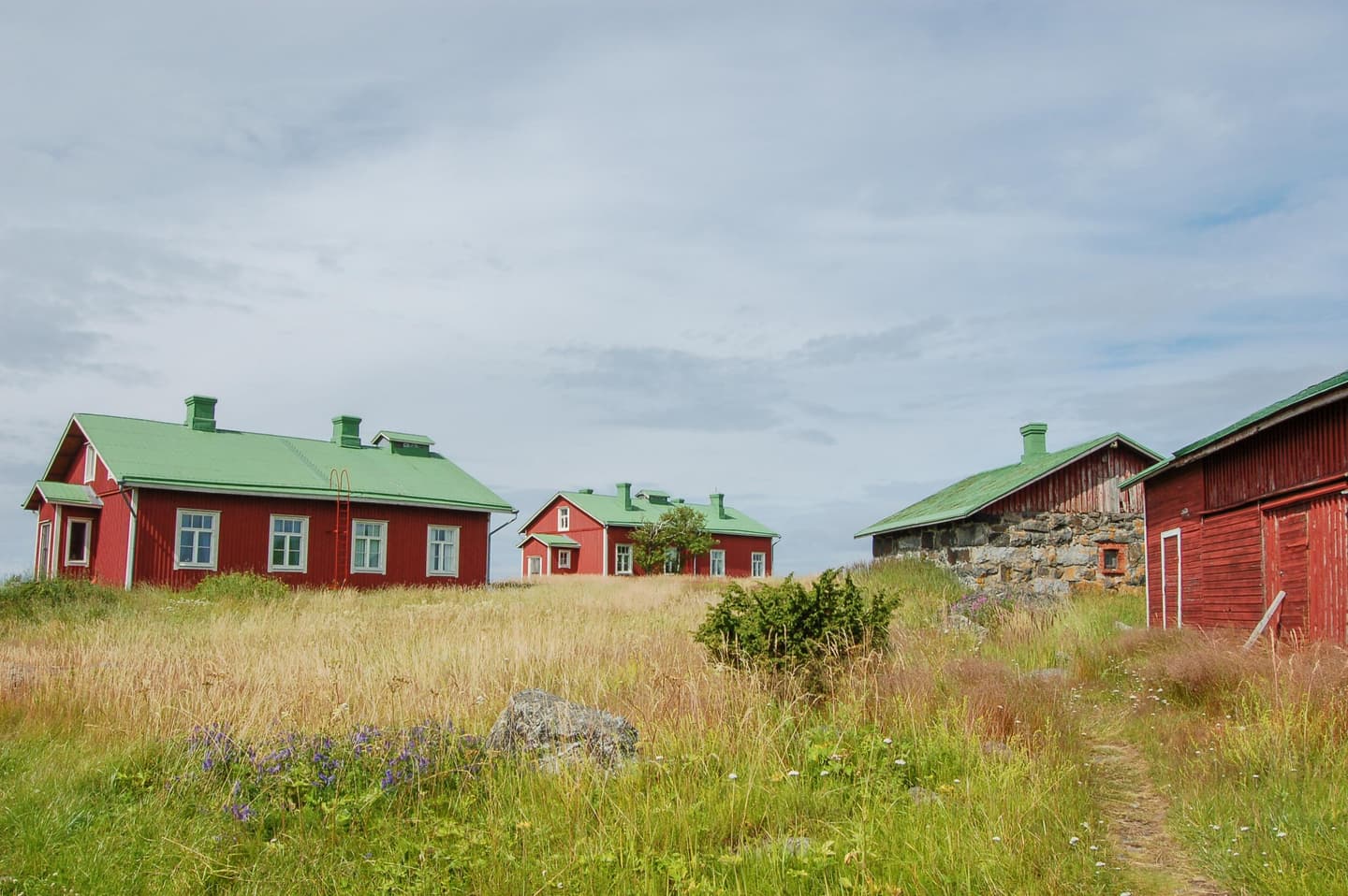 Image: Saara Airaksinen Red, old buildings. There is a meadow in the courtyard.