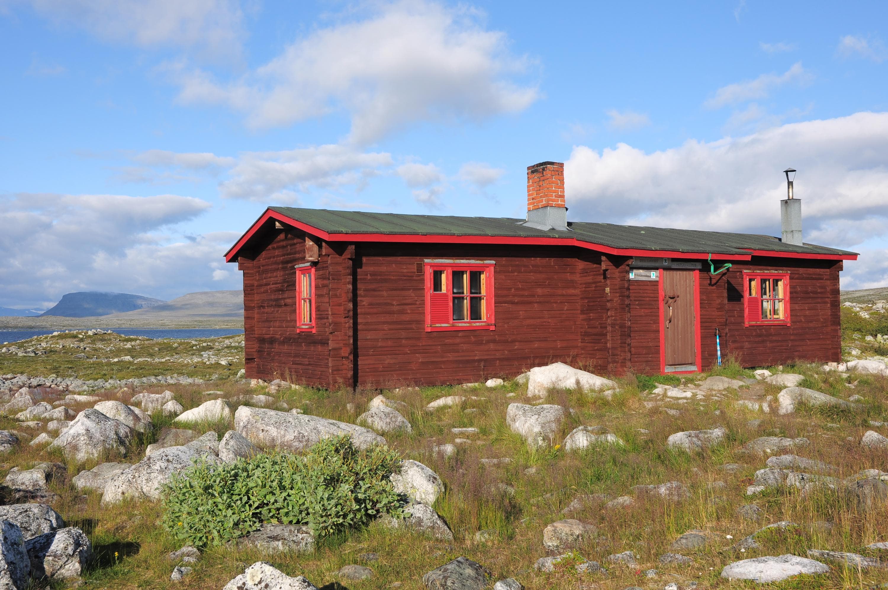 Image: Seija Olkkonen Ruskea yksikerroksinen puurakennus avarassa tunturimaisemassa.