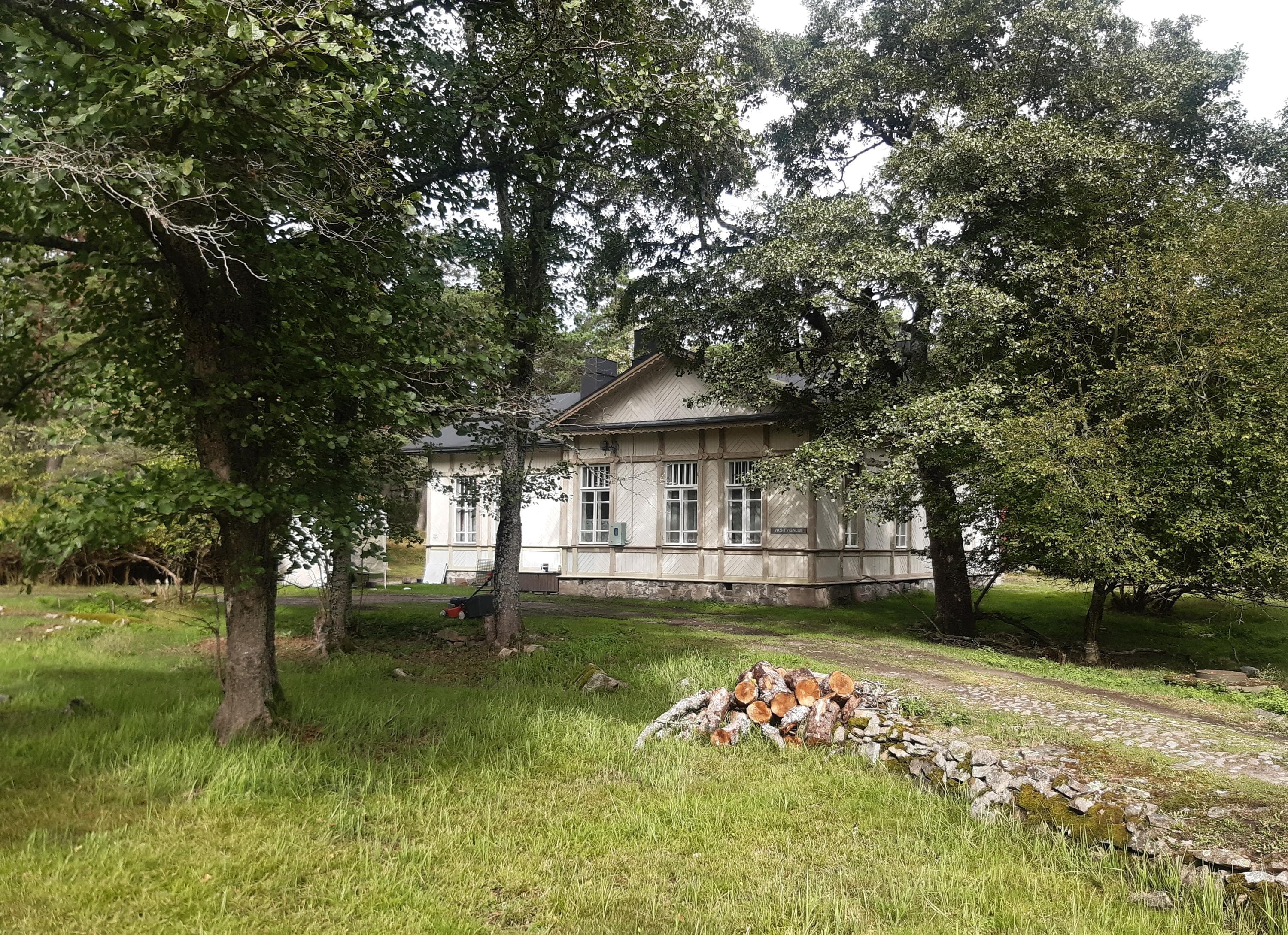 Image: Kirsi Nikkola An old white-painted villa building is visible through the deciduous trees.