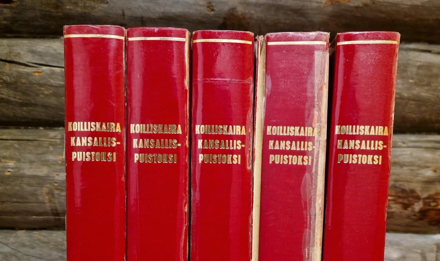 Kuva: Kristiina Aikio Kuvassa on vierekkäin viisi punakantista, paksua kirjaa. Ne sisältävät 100 000 allekirjoitusta.