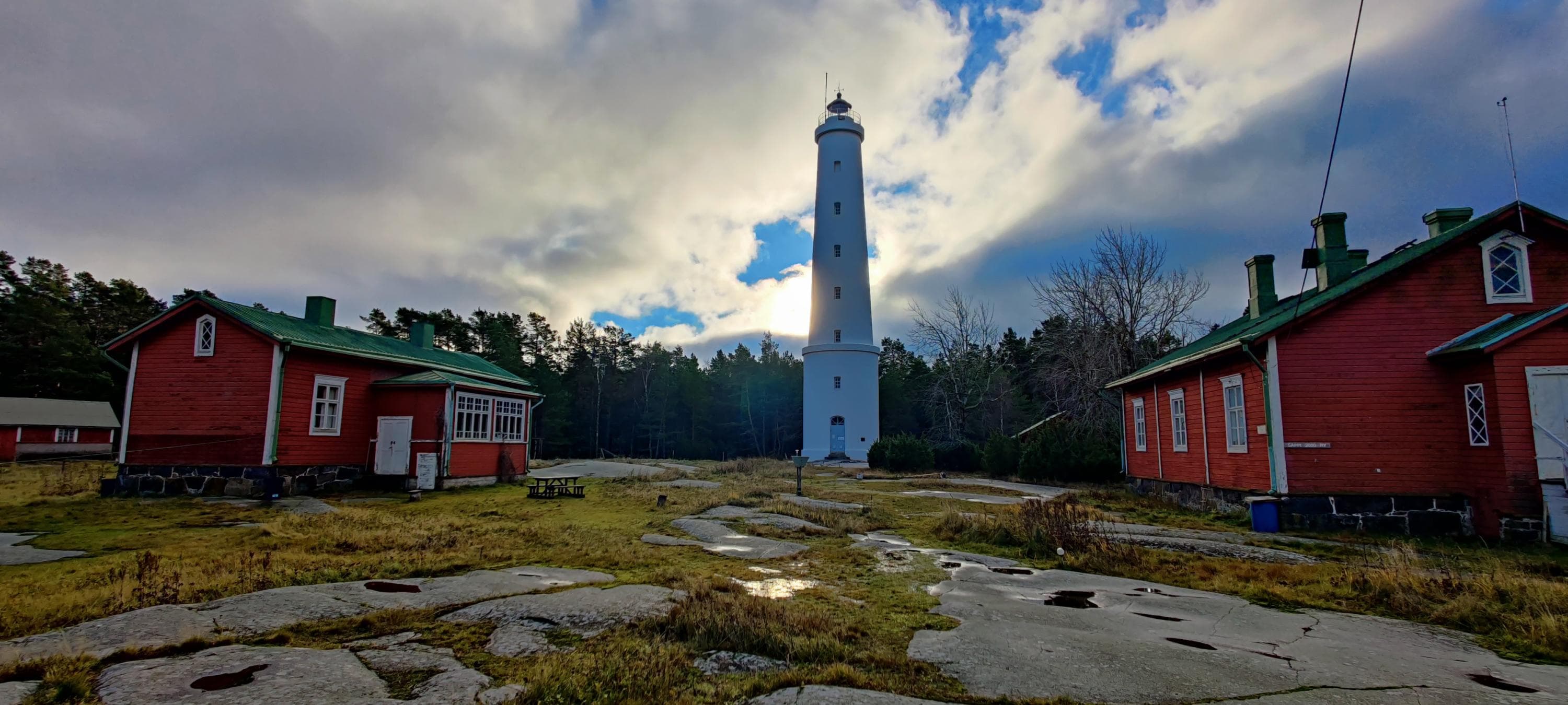 Image: Marjo Kekki Red-painted buildings and a tall white lighthouse.