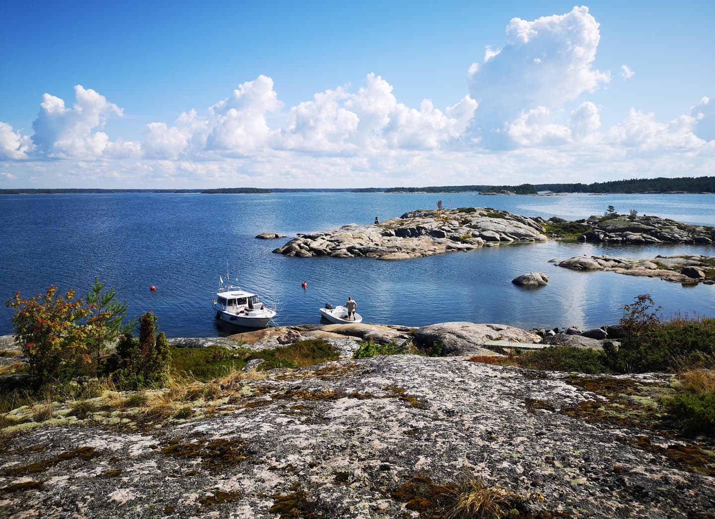 Kuva: Marjo Kekki Kivikkoista merenrantaa. Rantaan on kiinnittynyt pieni vene.