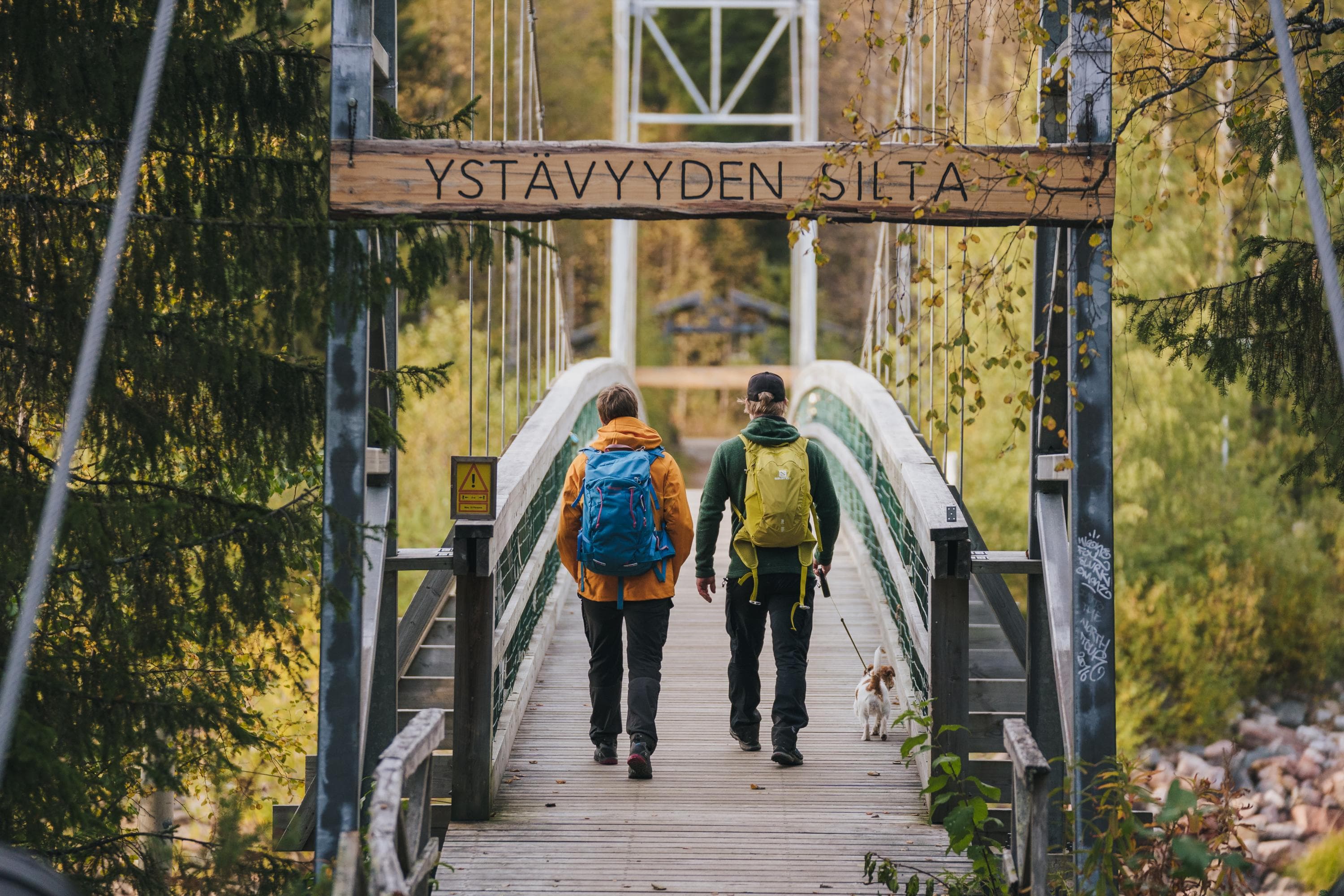 Kuva: Jaakko Posti Kaksi retkeilijää ylittämässä Vikakönkään riippusiltaa Napapiirin retkeilyalueella.