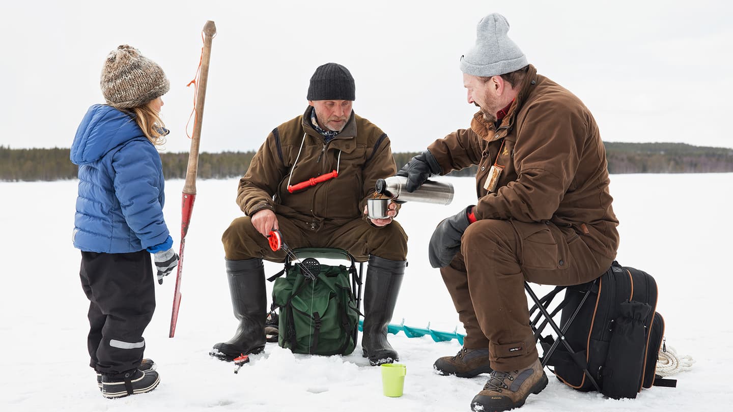 Kuva: Katri Lehtola / Keksi Kaksi henkilöä pilkkii ja istuu jäällä pilkkijakkaroilla, heidän vieressään vasemmalla puolella seisoo lapsi.