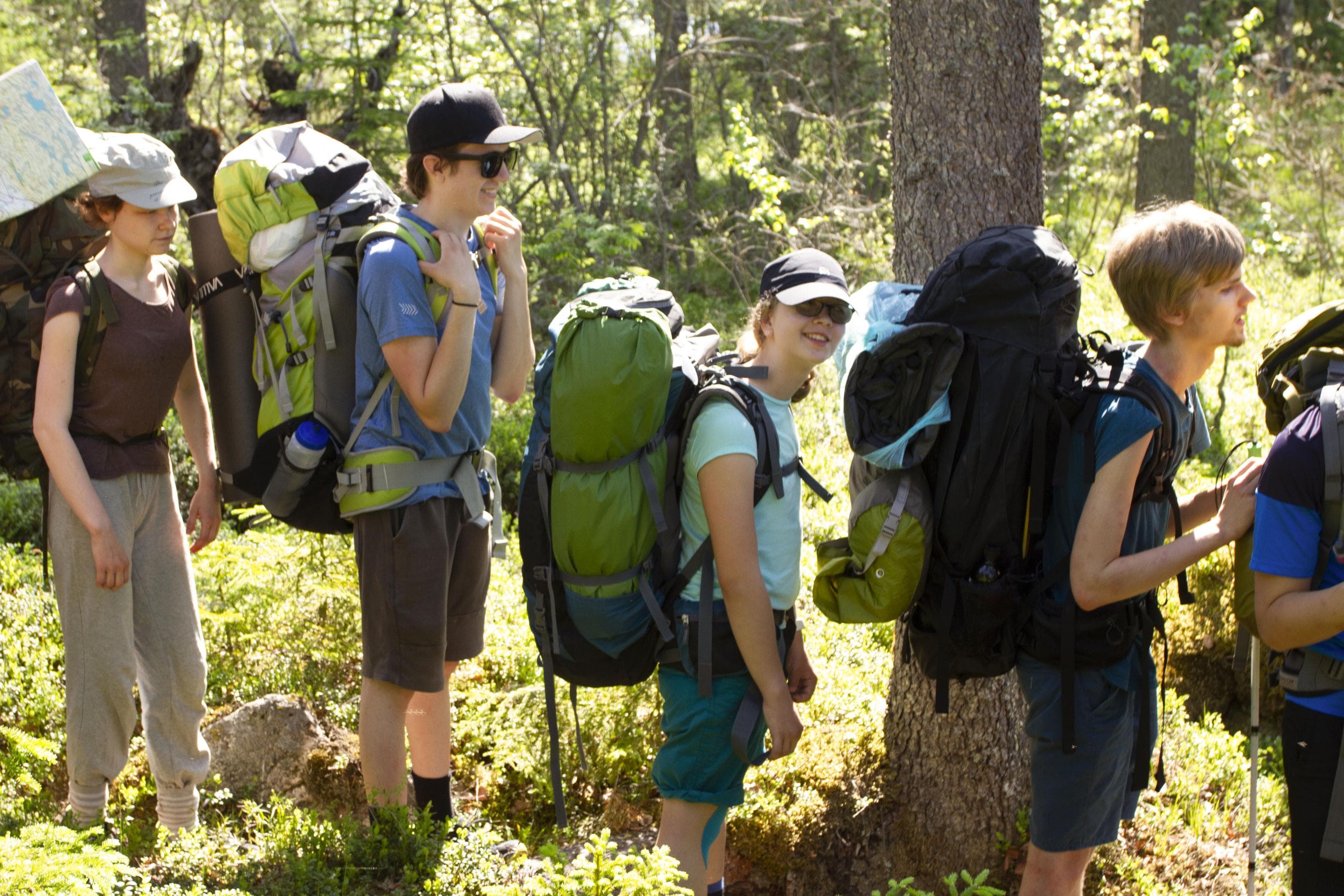 Kuva: Anemone Aaltonen Ryhmä nuoria seisoo metsäpolulla rinkat selässä.