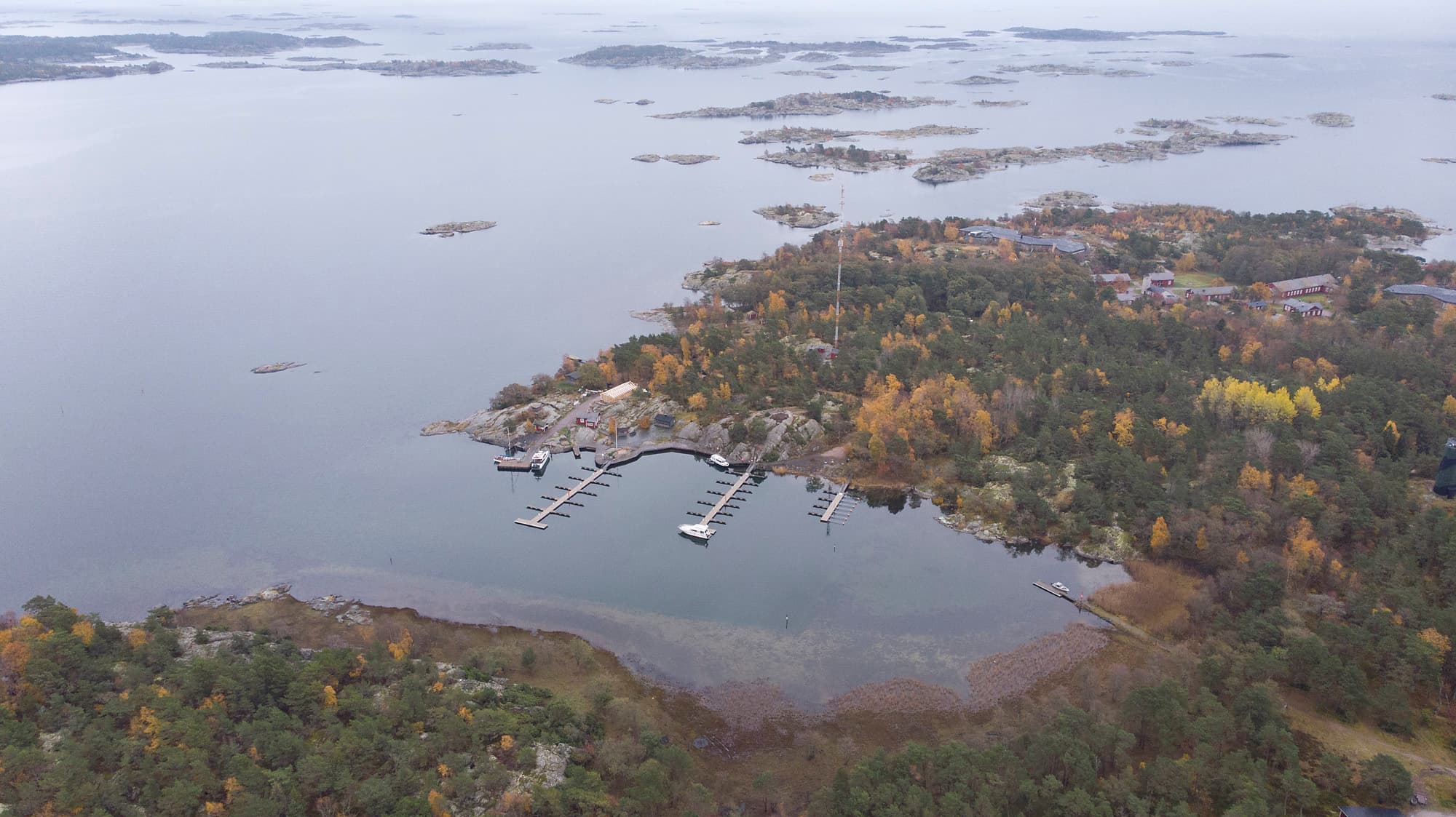 Image: Jarmo Vehkakoski Aerial view showing forest, beach, sea, piers and boats. There is autumn.