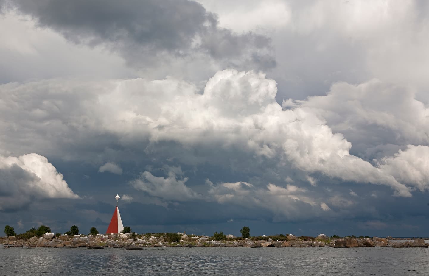 Image: Seppo Keränen A sailboat is visible on the sea in the distant horizon. There are storm clouds in the sky.