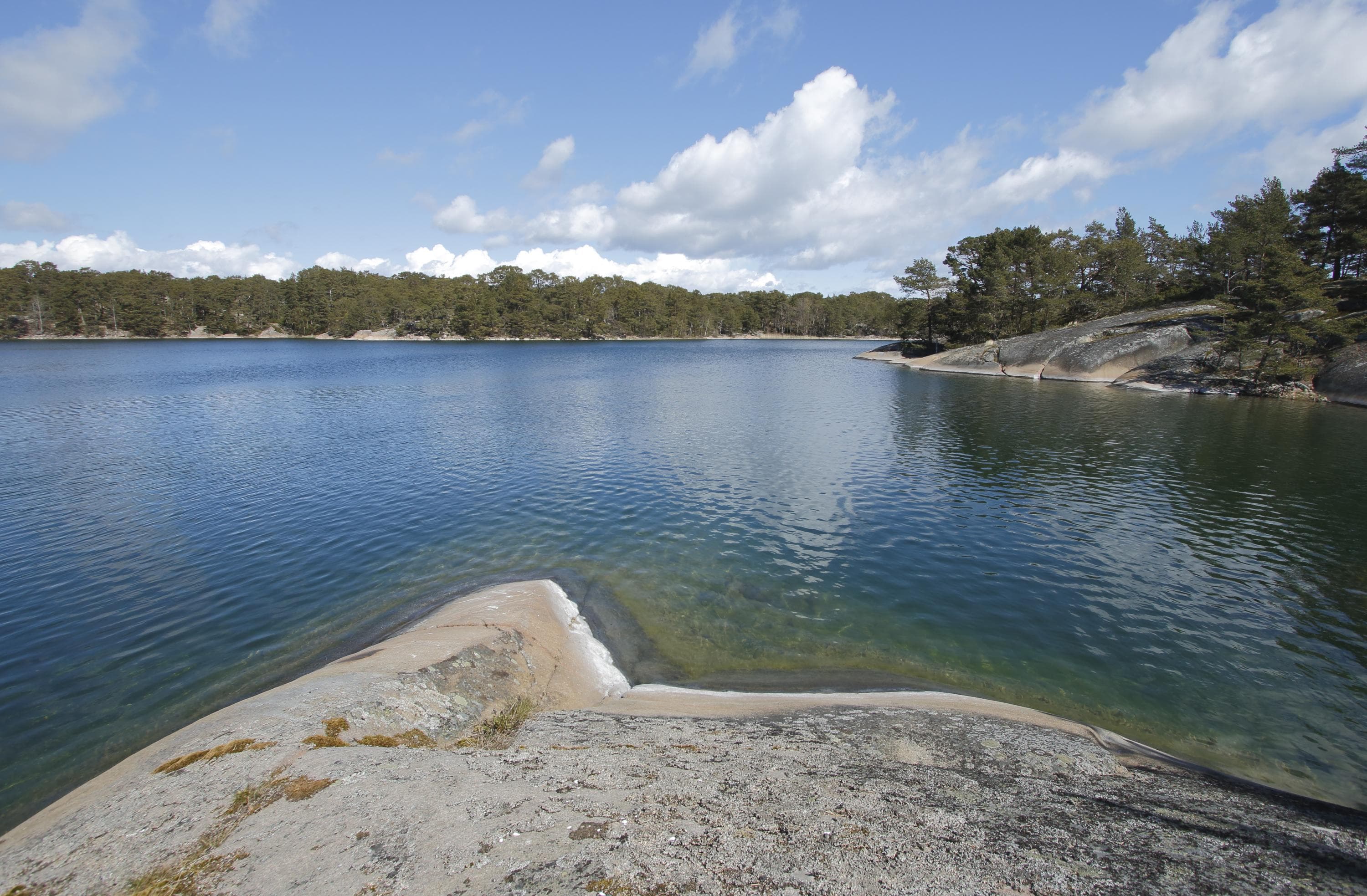 Image: Jussi Helimäki Cliffs, further back wooded cliffs on the shores of a calm bay.