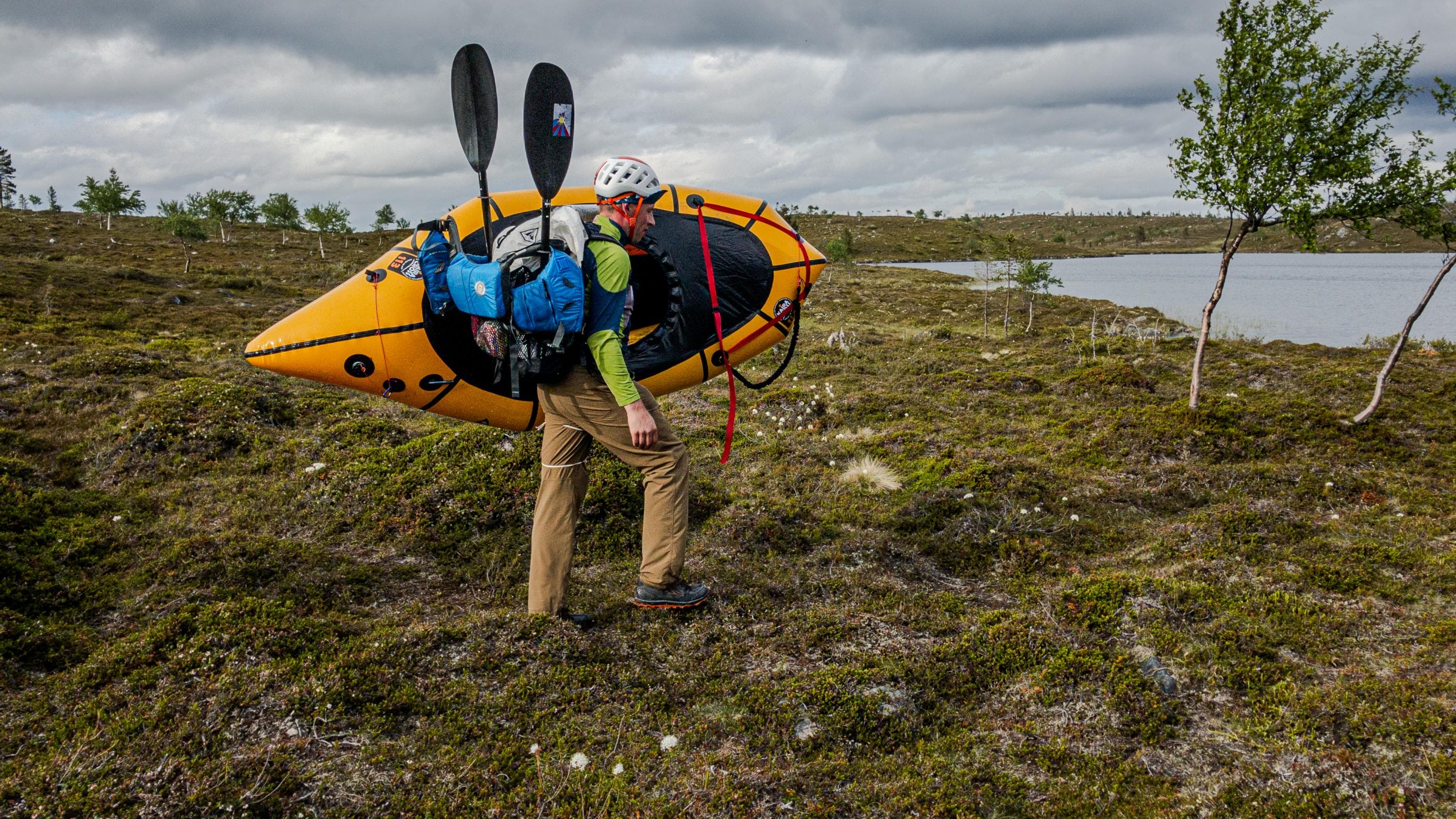 Kuva: Jussi Riku Reppulauttailija kantaa lauttaansa kohti vettä.