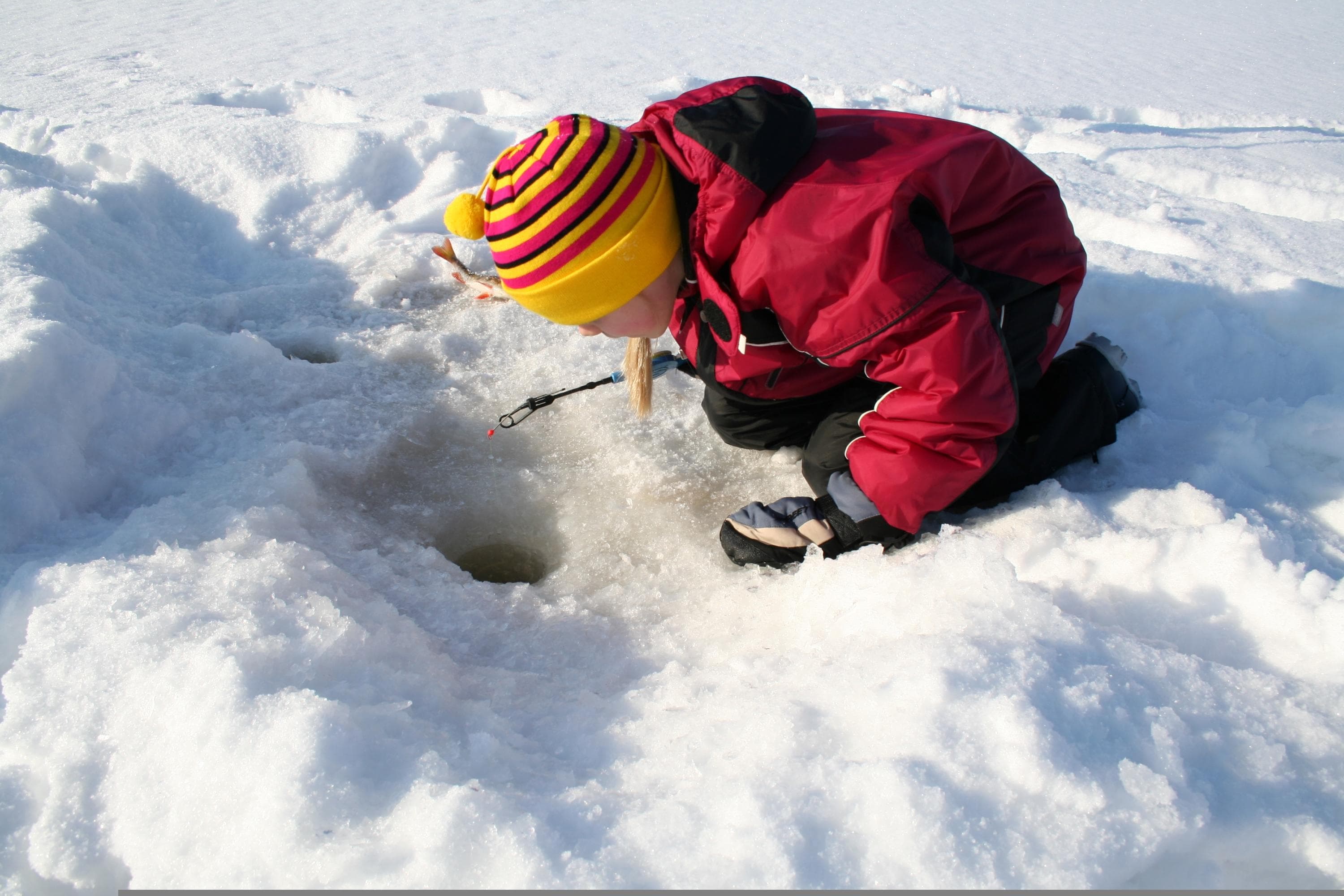 Kuva: Meini Nivaoja / Kuvatoimisto Vastavalo Pieni lapsi pilkkireiän äärellä.