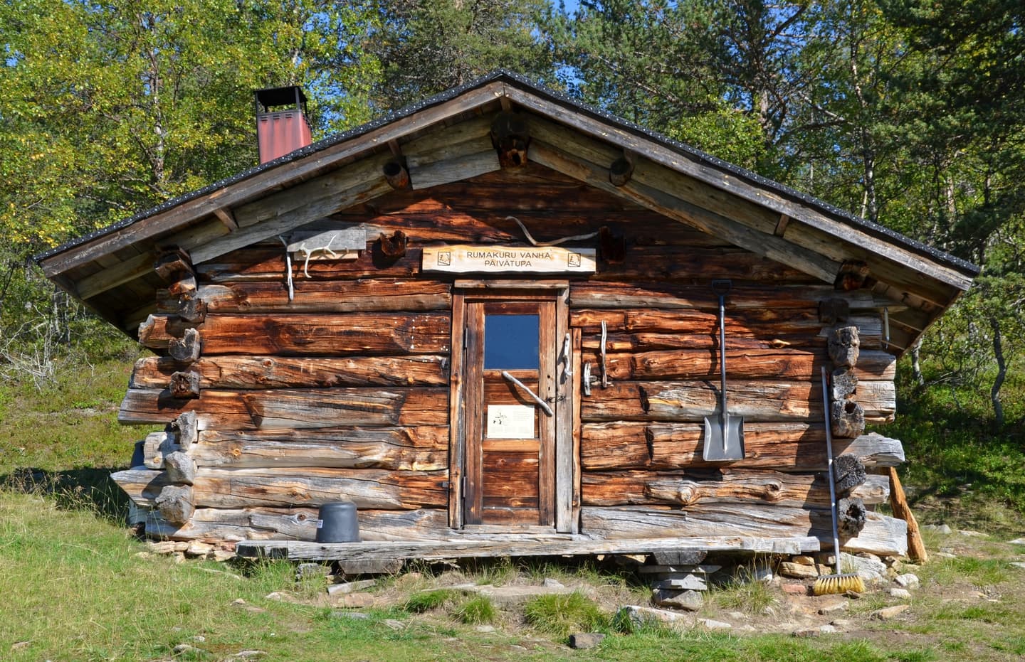 Kuva: Pasi Nivasalo Vanha tupa auringonpaisteessa. Tuvan ympärillä on vihreää ruohoa.