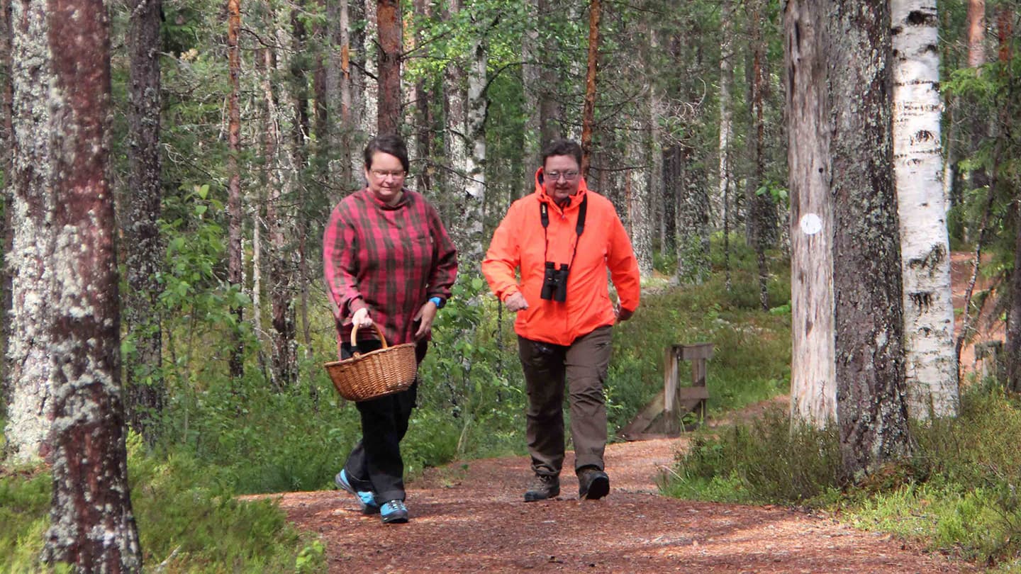 Kuva: Sari Airas Kaksi värikkäästi pukeutunutta retkeilijää kävelee polkua pitkin.