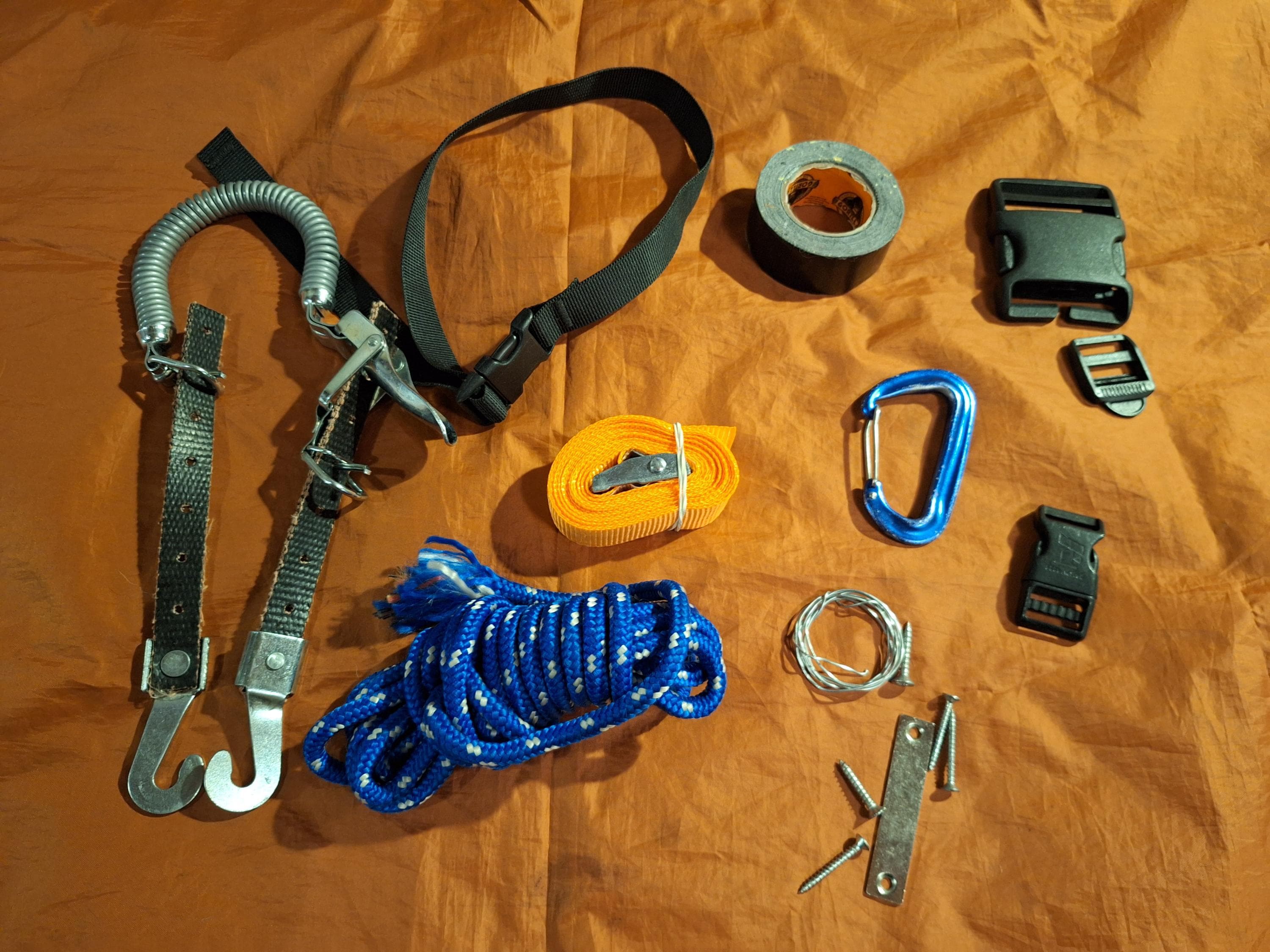 Image: Maria Makkonen Repair tools spread out on a surface, including a spare ski binding with a strap to attach behind the boot.