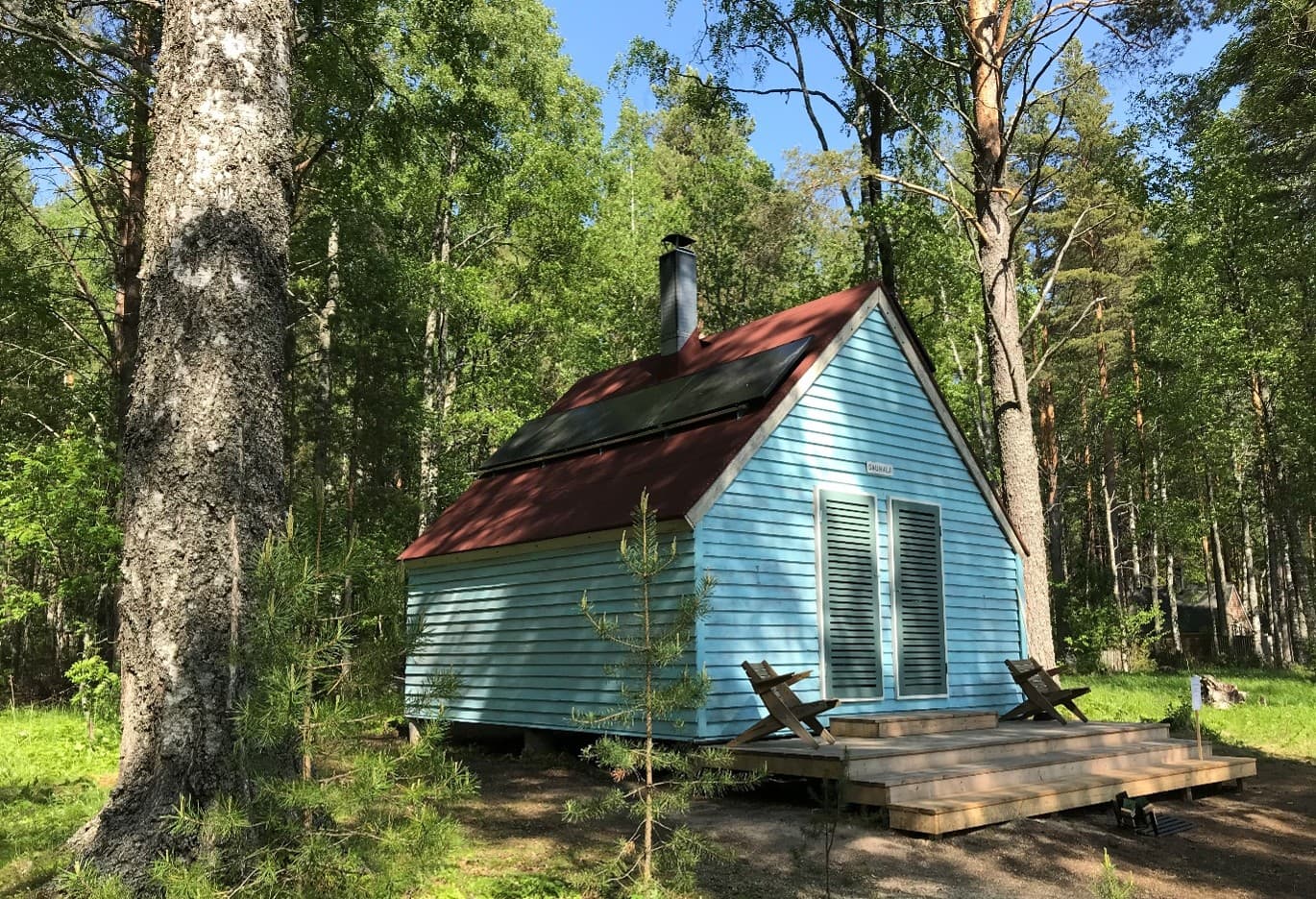 Kuva: Metsähallitus. Kuvan keskellä pieni tupa. Vasemmassa reunassa suuri puu. Taustalla metsää.
