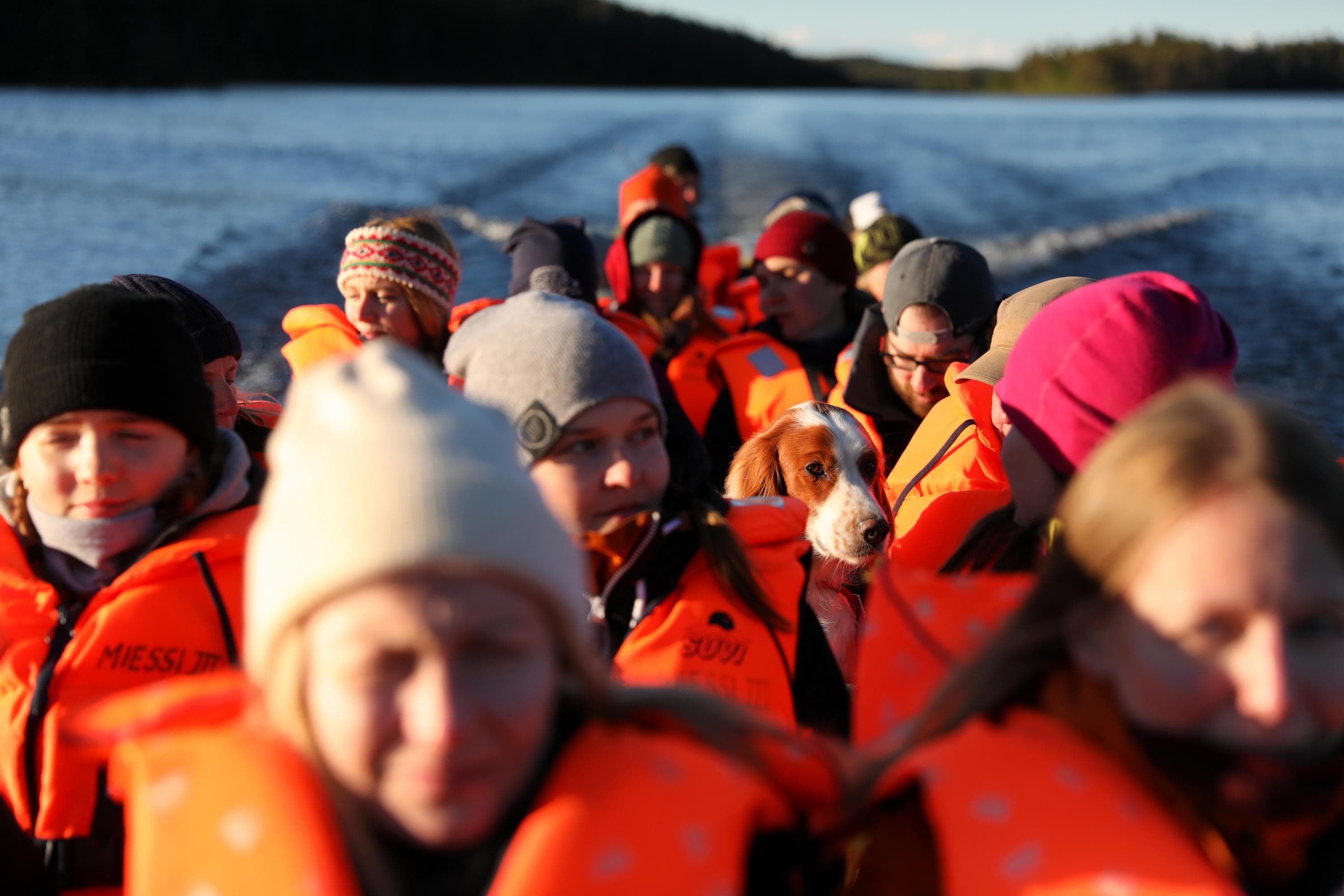 Kuva: Harri Tarvainen Pitkässä veneessä ihmisiä pelastusliivi yllä sekä koira. Taustalla jokimaisema.