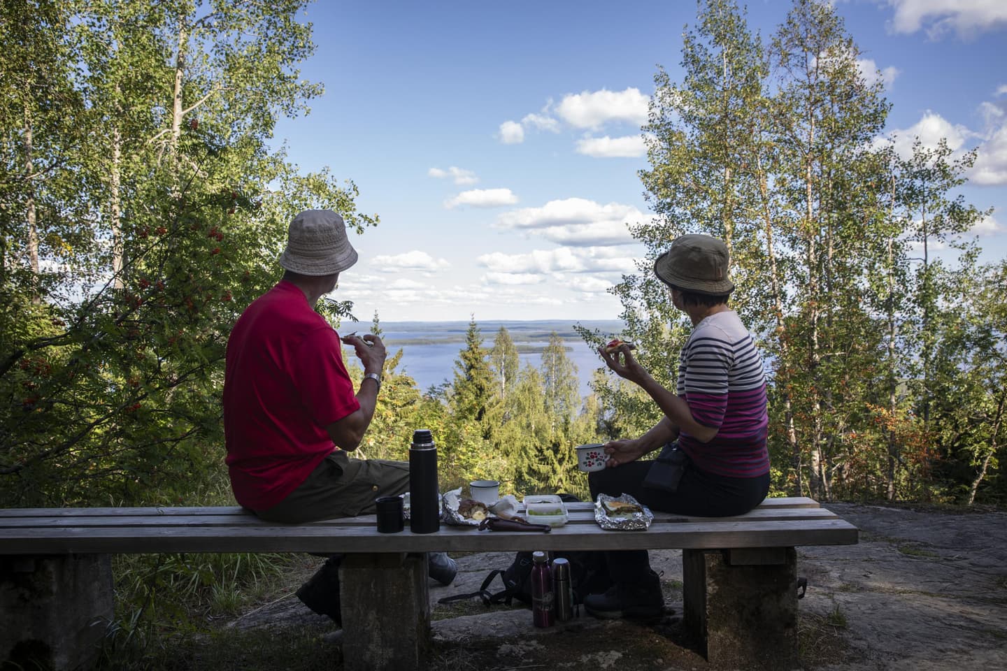 Image: Saara Lavi Two hikers are sitting on a bench, enjoying a break with a view.