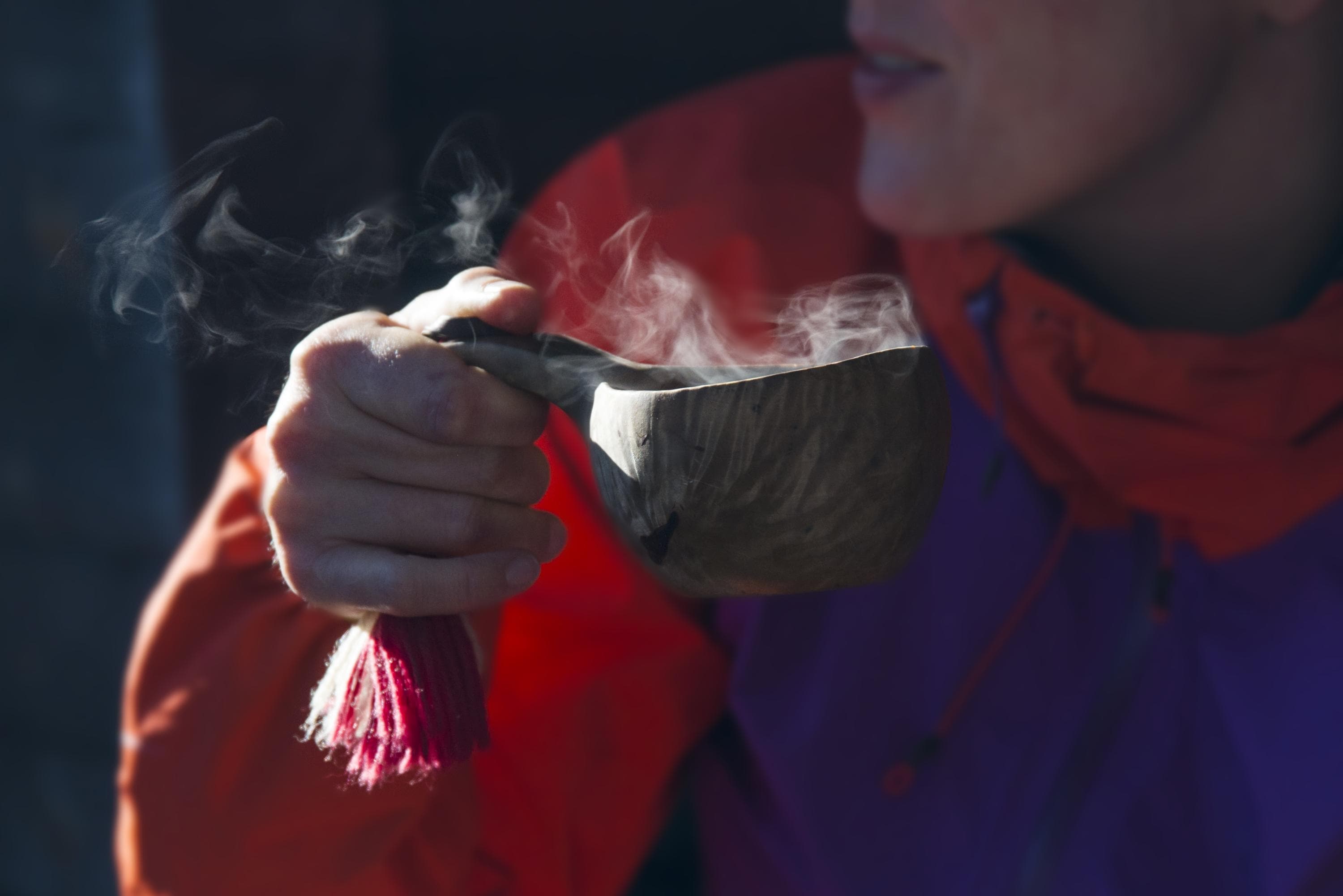 Image: Teemu Kuisma A hiker is holding a wooden kuksa cup with steaming hot drink.
