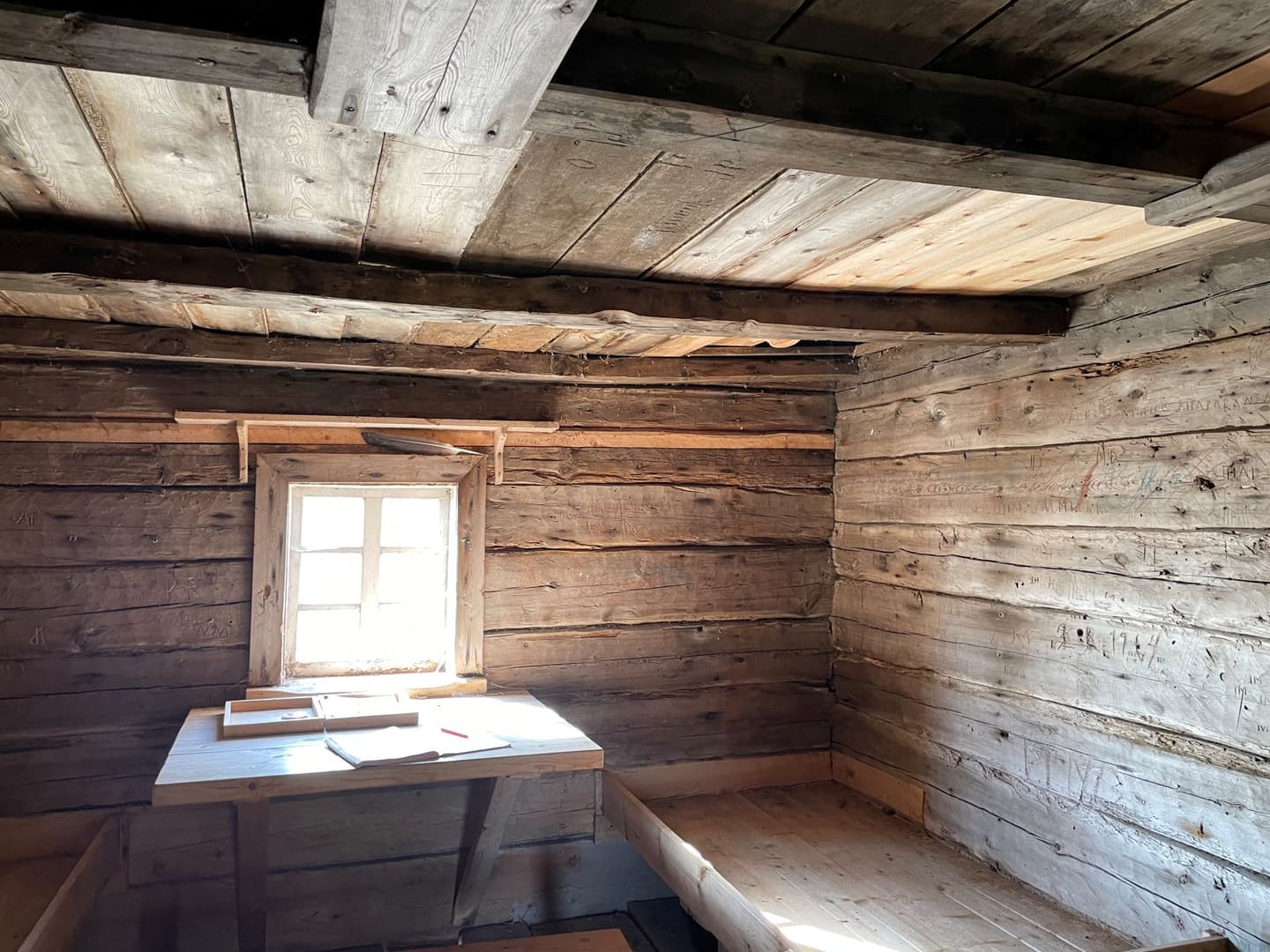 Image: Päivi Tervonen A bright light shines through the small window into the old wooden building.