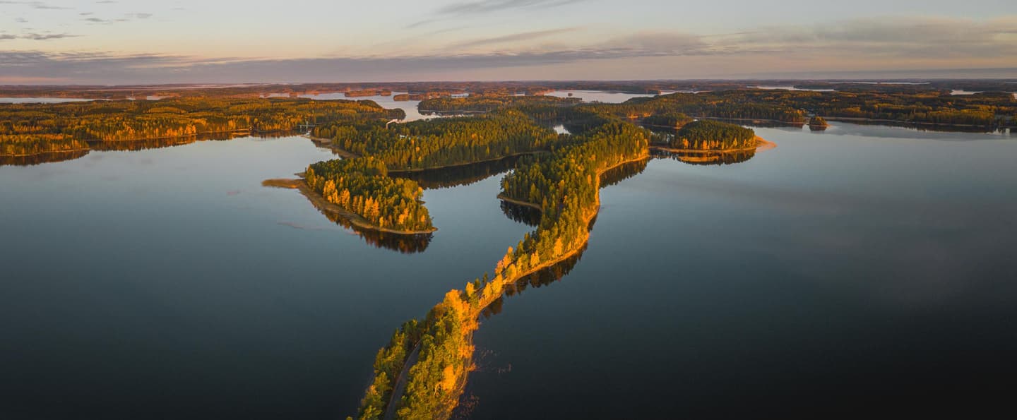 Image: Jussi Silvennoinen A calm lake is crossed by a narrow forested ridge.