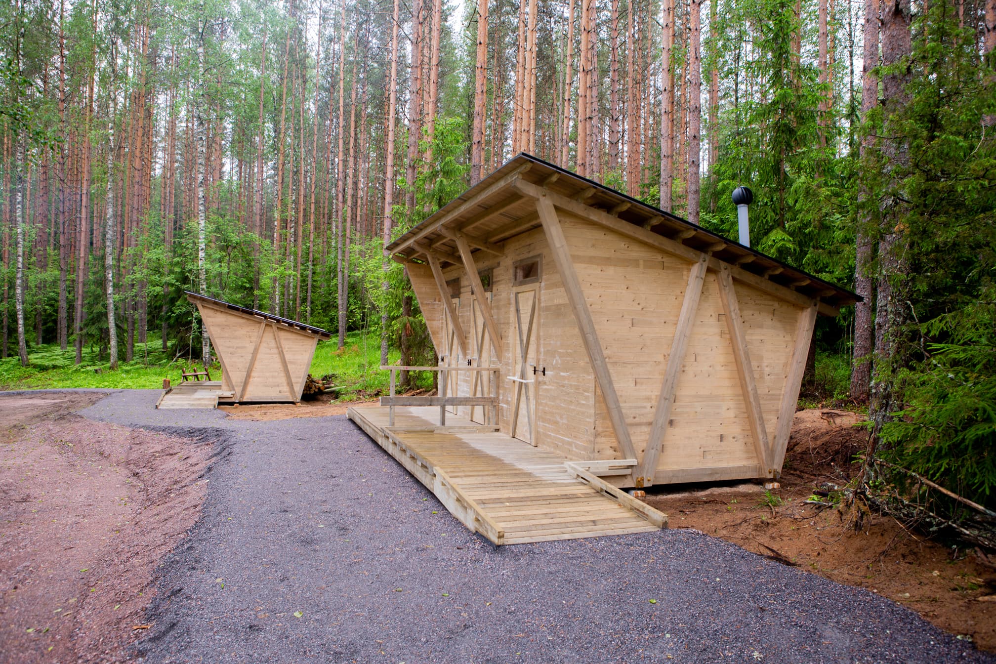 Kuva: Joel Heino Puinen viistokattoinen matala rakennus. Rakennuksen edessä kulkee tasainen kävelytie.