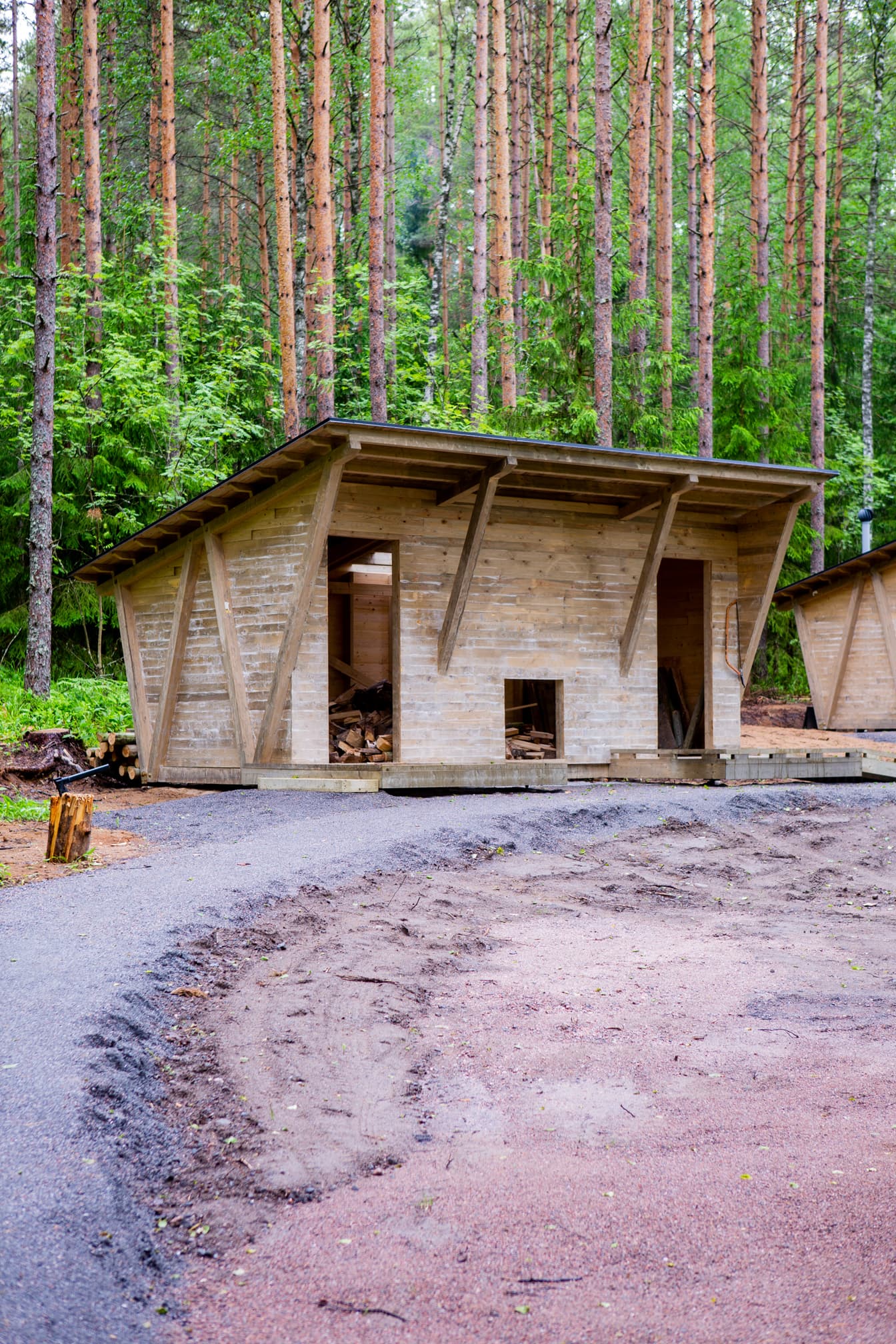 Kuva: Joel Heino Puinen rakennus jossa kaksi avonaista oviaukkoa. Rakennuksen edessä on tasainen kävelytie.
