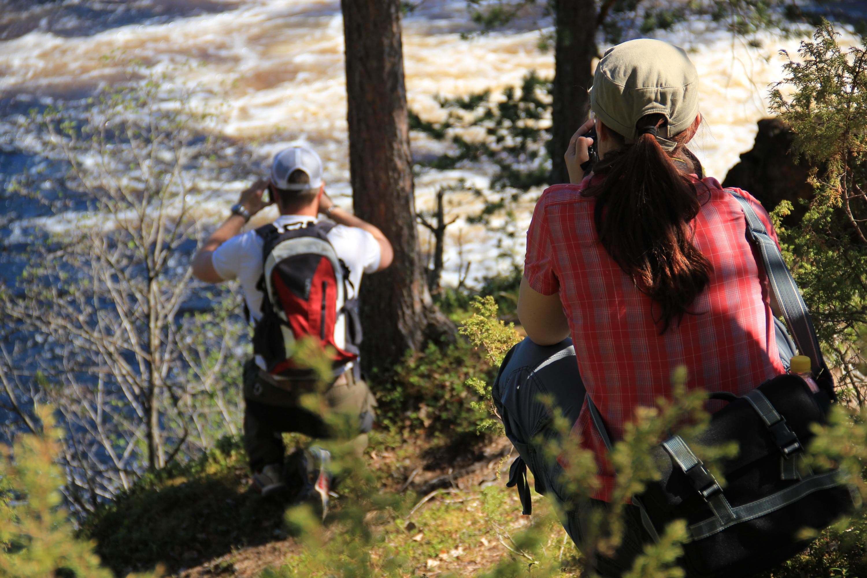 Kuva: Minna Niinistö Kaksi kyykistynyttä valokuvaajaa kuvaa kuohuvaa koskea.