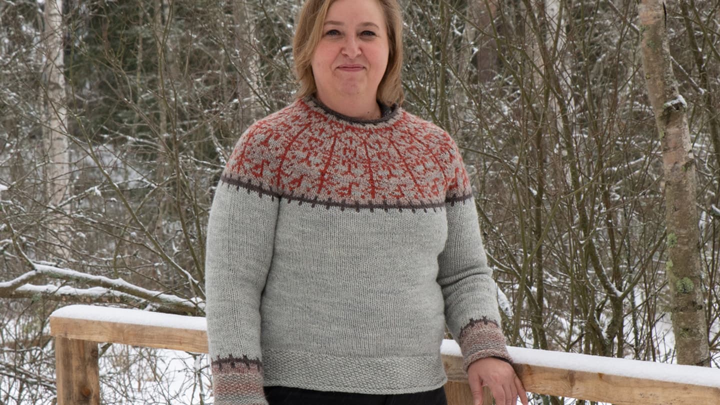 Image: Tanja Seppälä The person is wearing a grey wool jumper with rock painting motifs on the upper part, during winter.
