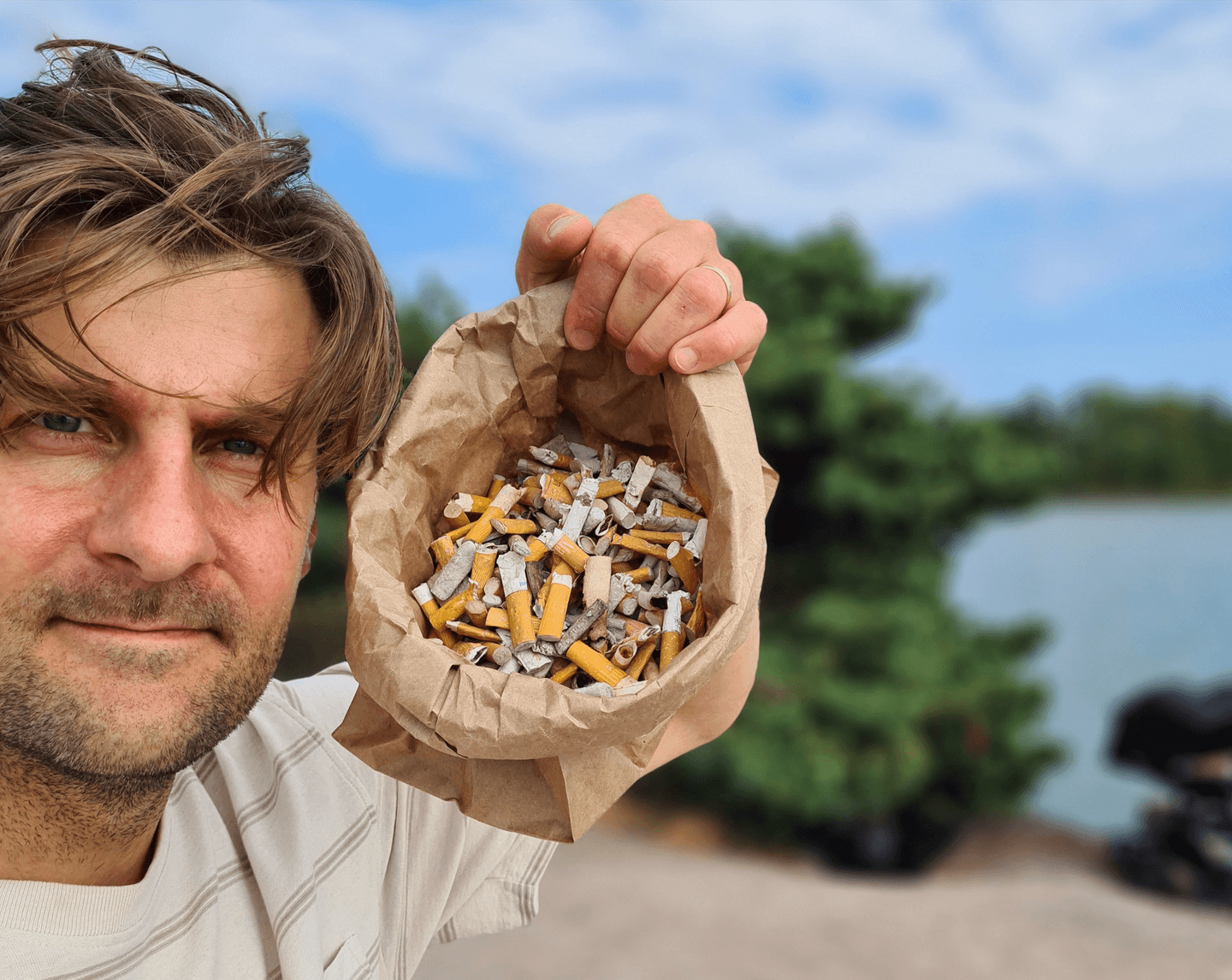 Image: Teemu Oinio In a close-up, the person has placed a paper bag beside head, filled with numerous cigarette butts.