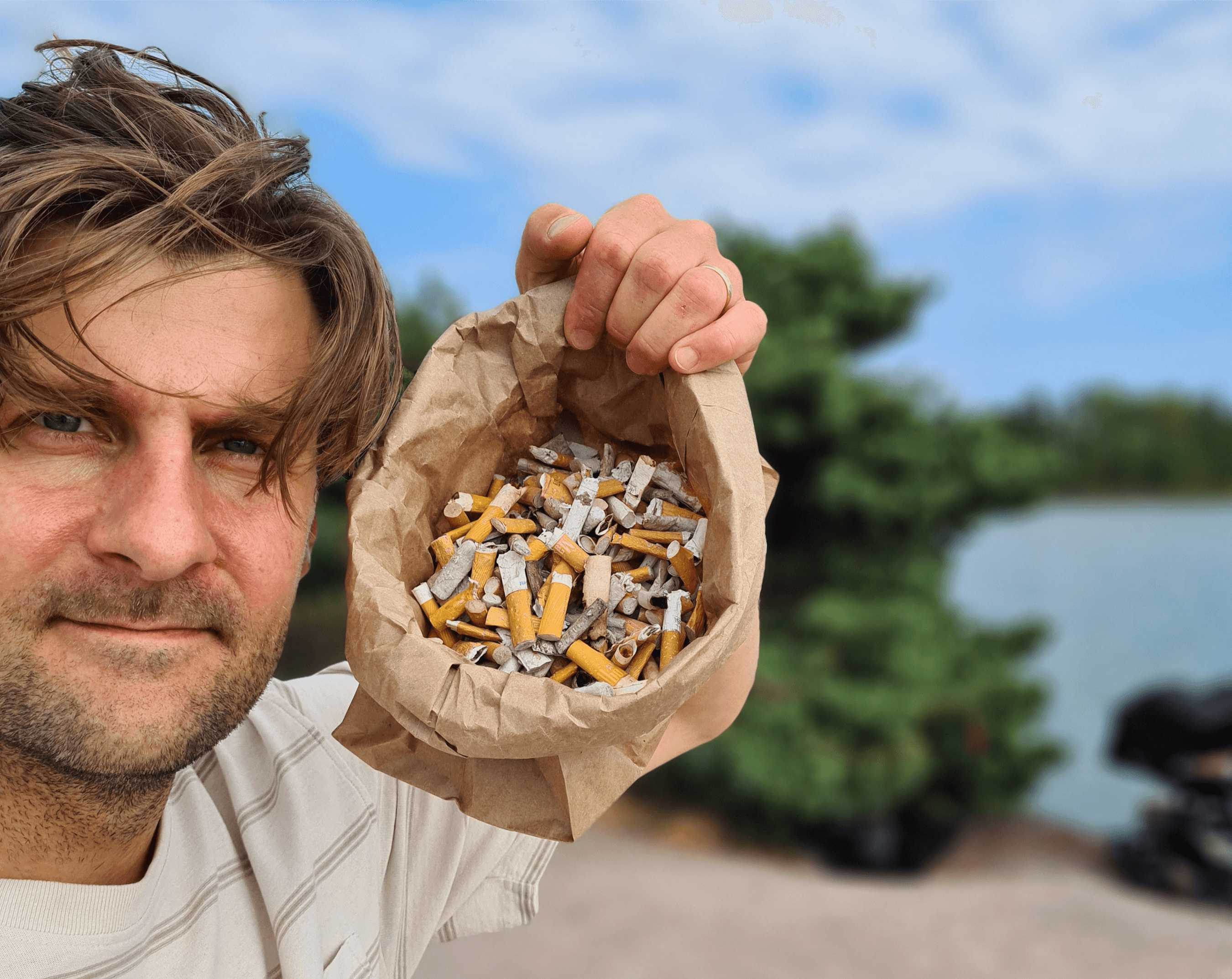Image: Teemu Oinio In a close-up, the person has placed a paper bag beside head, filled with numerous cigarette butts.