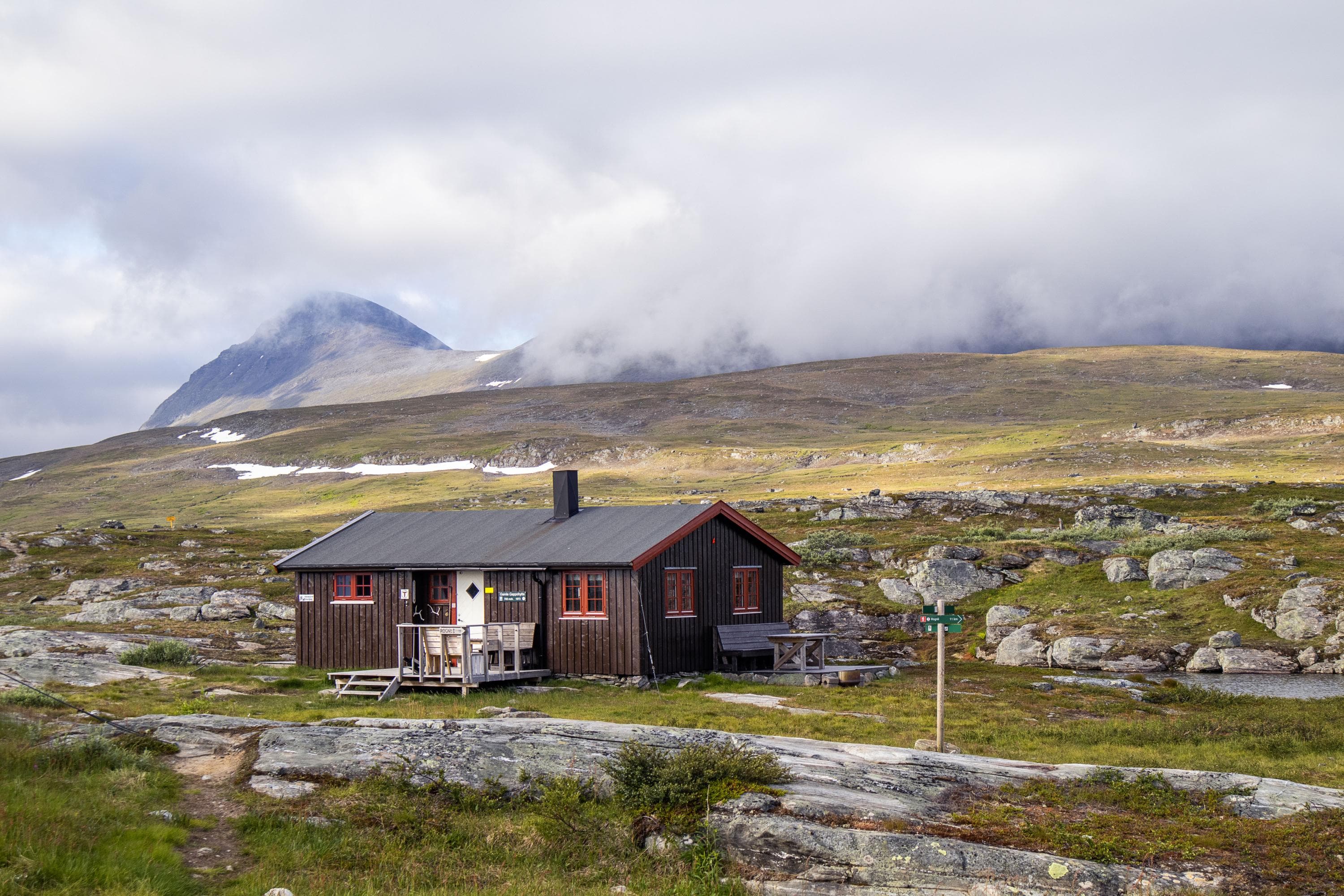 Kuva: Anna Pakkanen Lautarakennus ulkopenkkeineen. Taustalla sumuinen tunturimaisema.