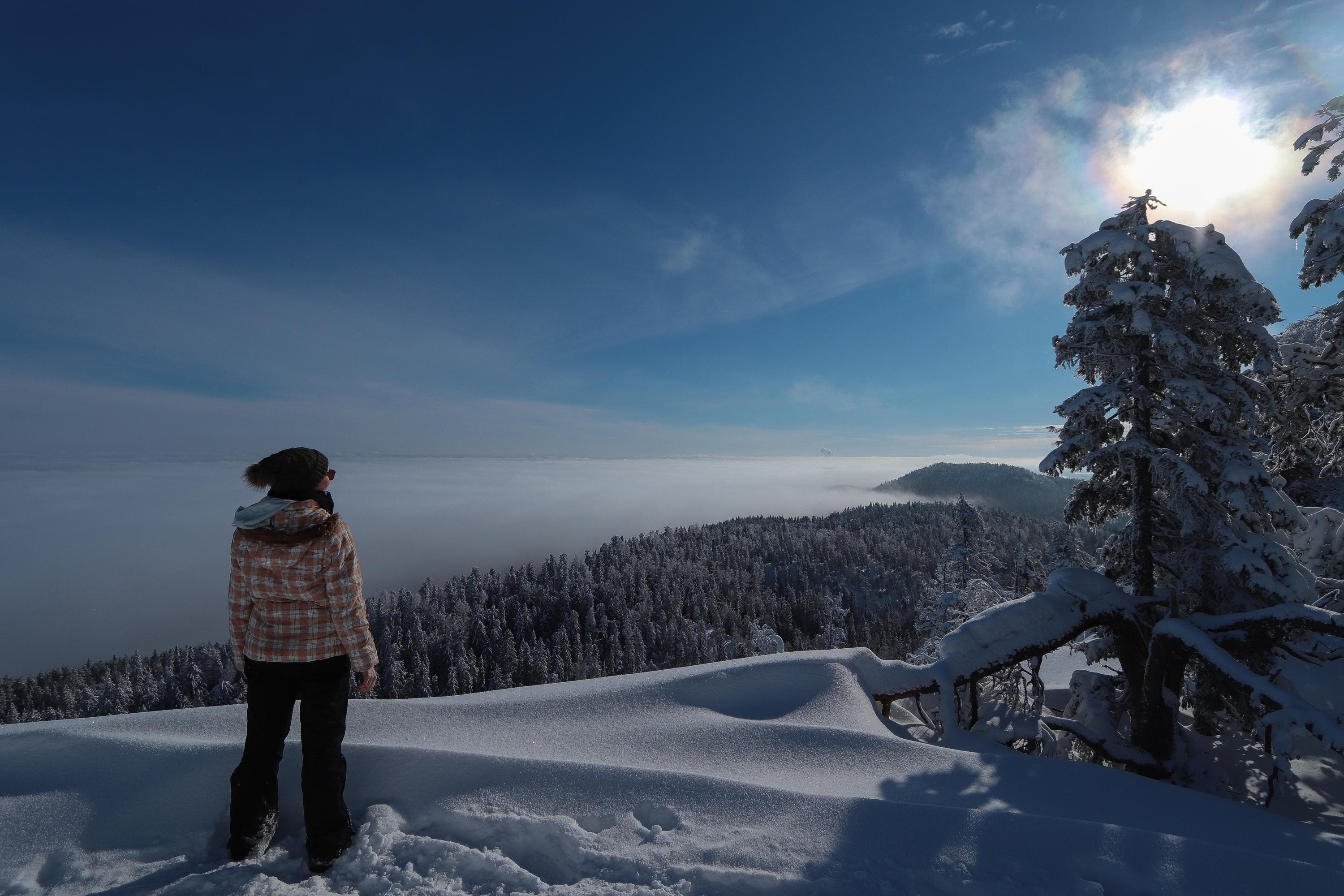 Bild: Tiina Koponen En vandrare står i orörd pudersnö. Det är kväll eller natt, men månen lyser klart.