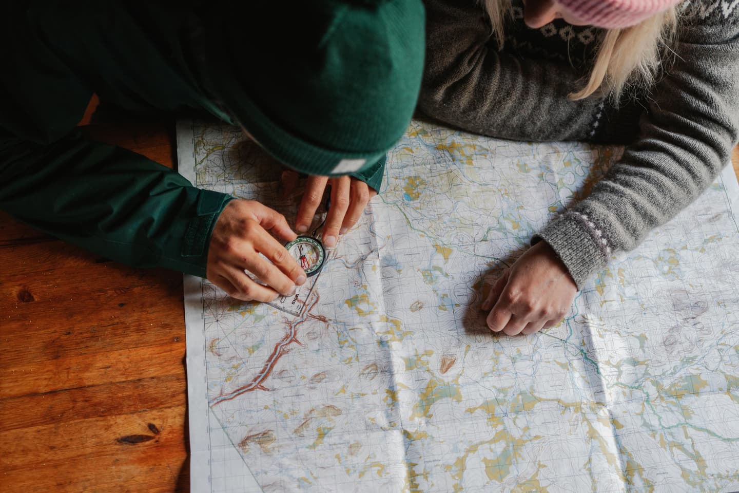 Image: Jaakko Posti Two people study a map and compass at a table.
