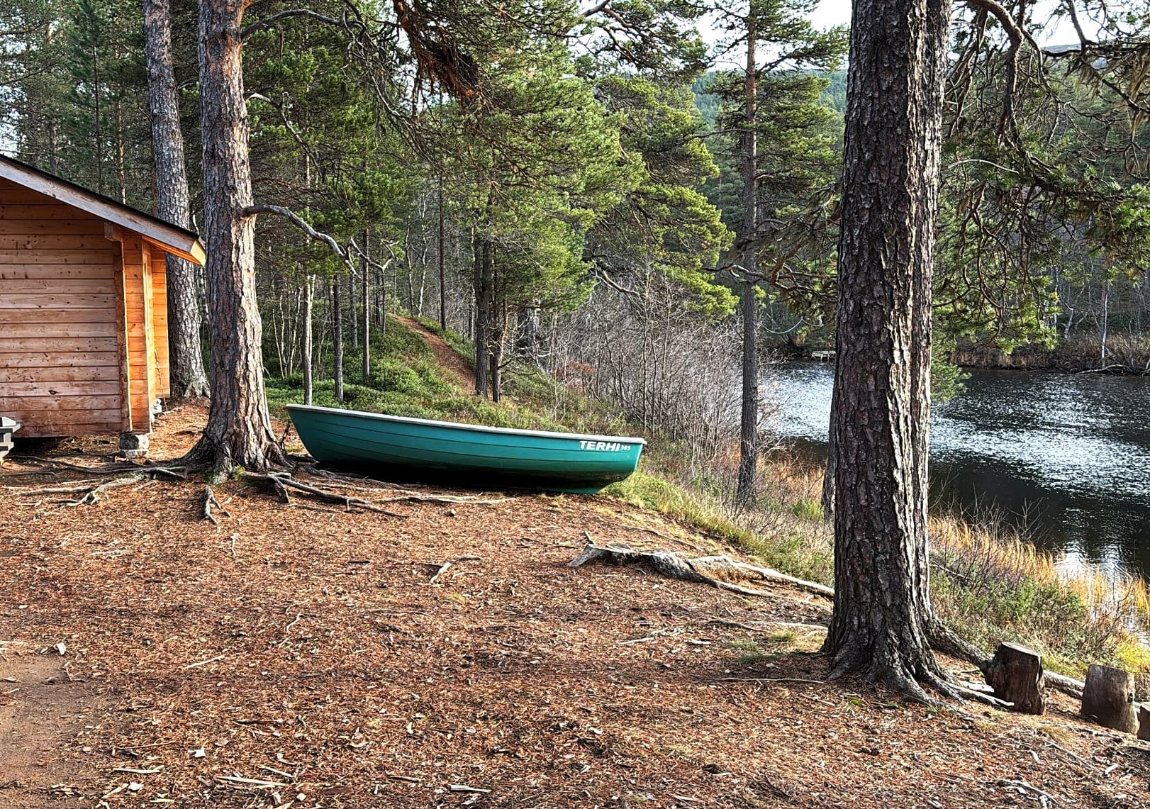 Båten är på torra land bredvid stugan.