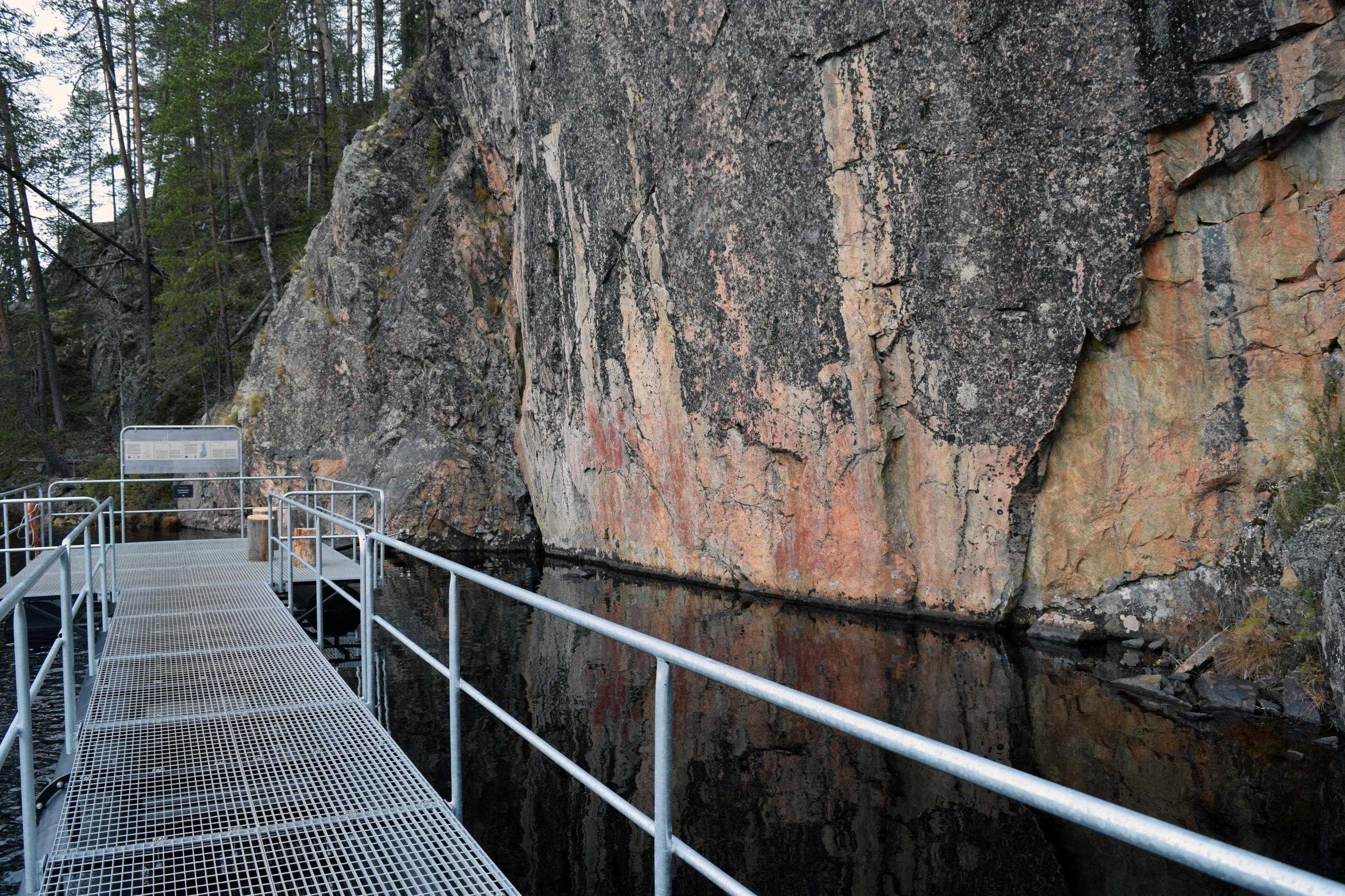 Kuva: Sirke Seppänen Jyrkkä kallioseinämä. Kallion edustalla on metallinen katselulava järven yllä.