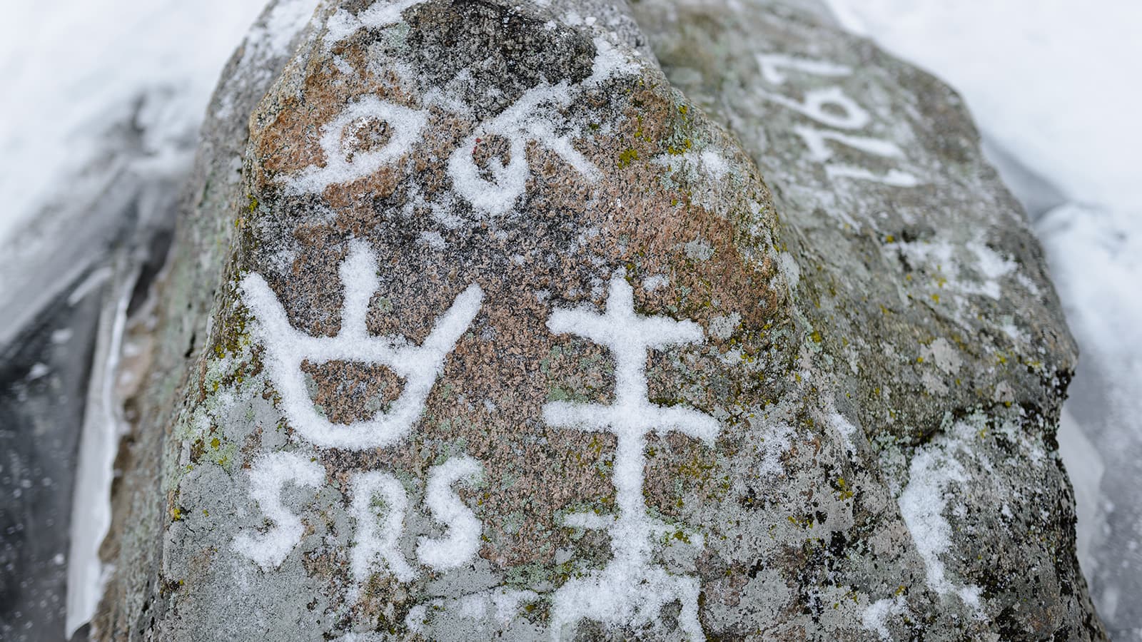 Kuva: Marko Haapalehto Kiven kyljestä erottuu kaiverrettuja merkintöjä lumen ansioista.
