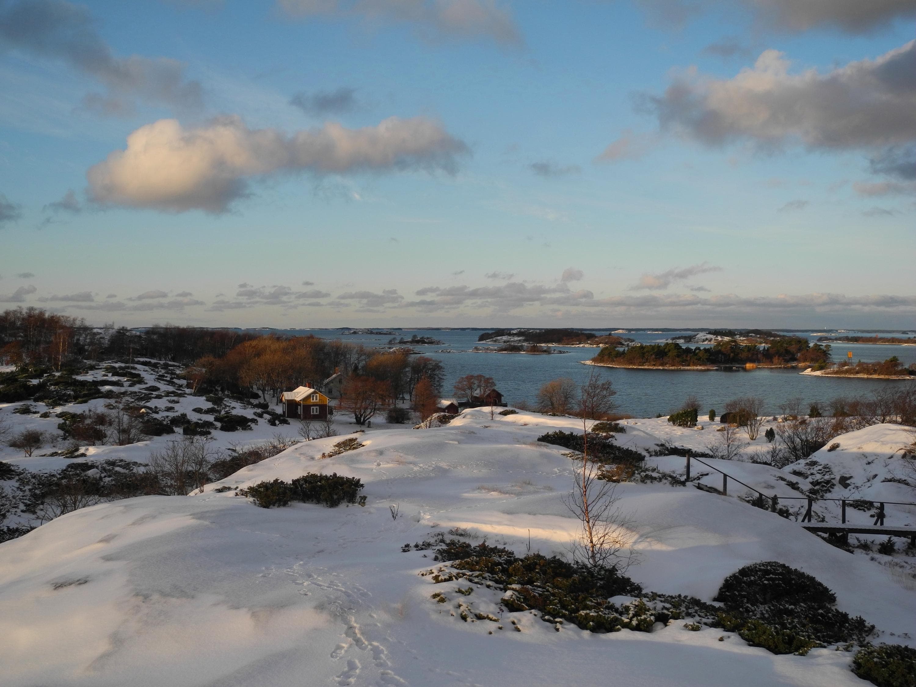 Bild: Sanna-Mari Rivasto Vinterlandskap i skärgården. Strandklippan är täckt av snö. Havet i bakgrunden är isfritt.