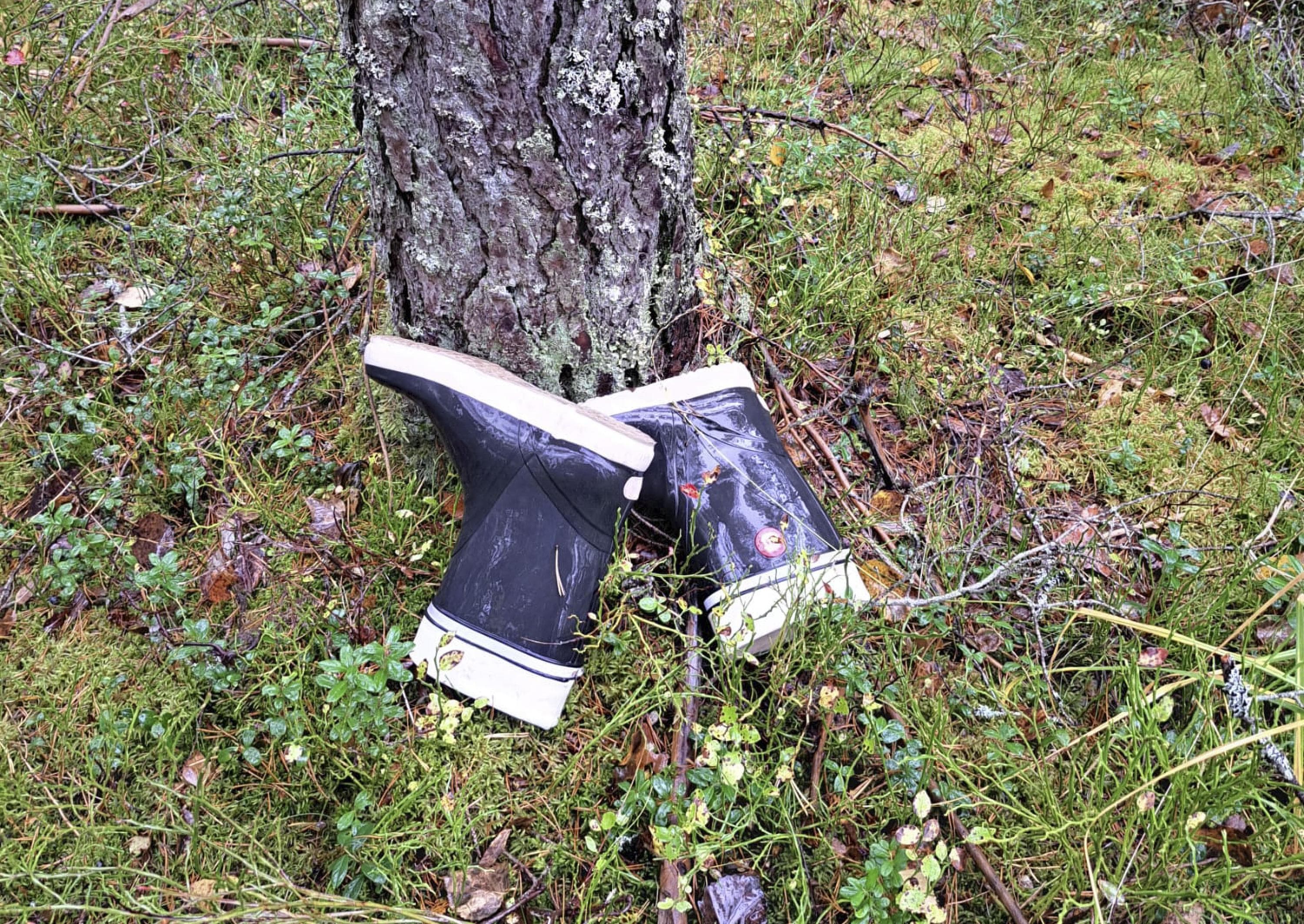 Bild: Helena Lunden Svartvita gummistövlar som lutar mot ett träd i skogen.
