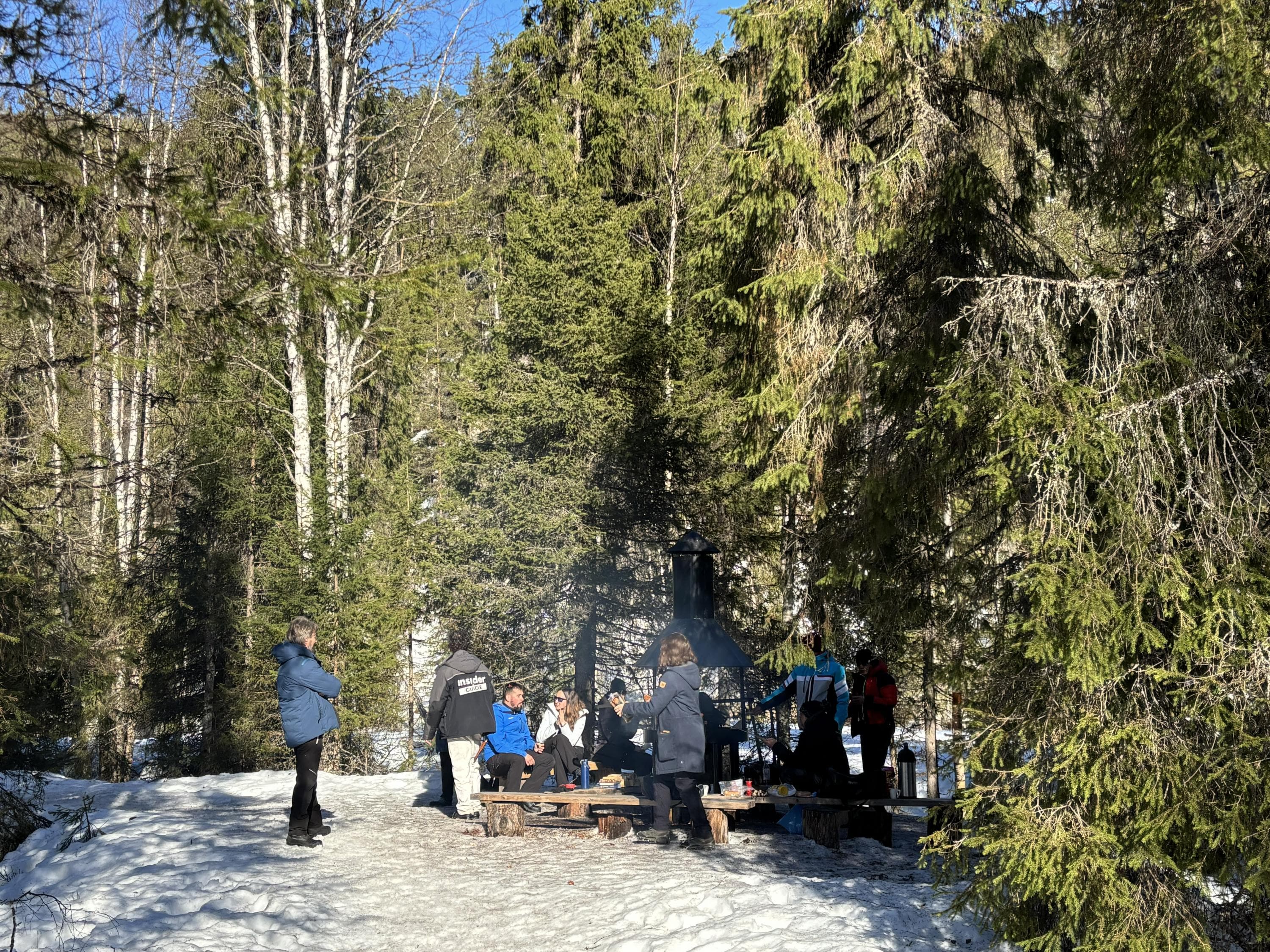Kuva: Eeva Pulkkinen Ihmisiä seisomassa ja istumassa tulentekopaikalla talvella.