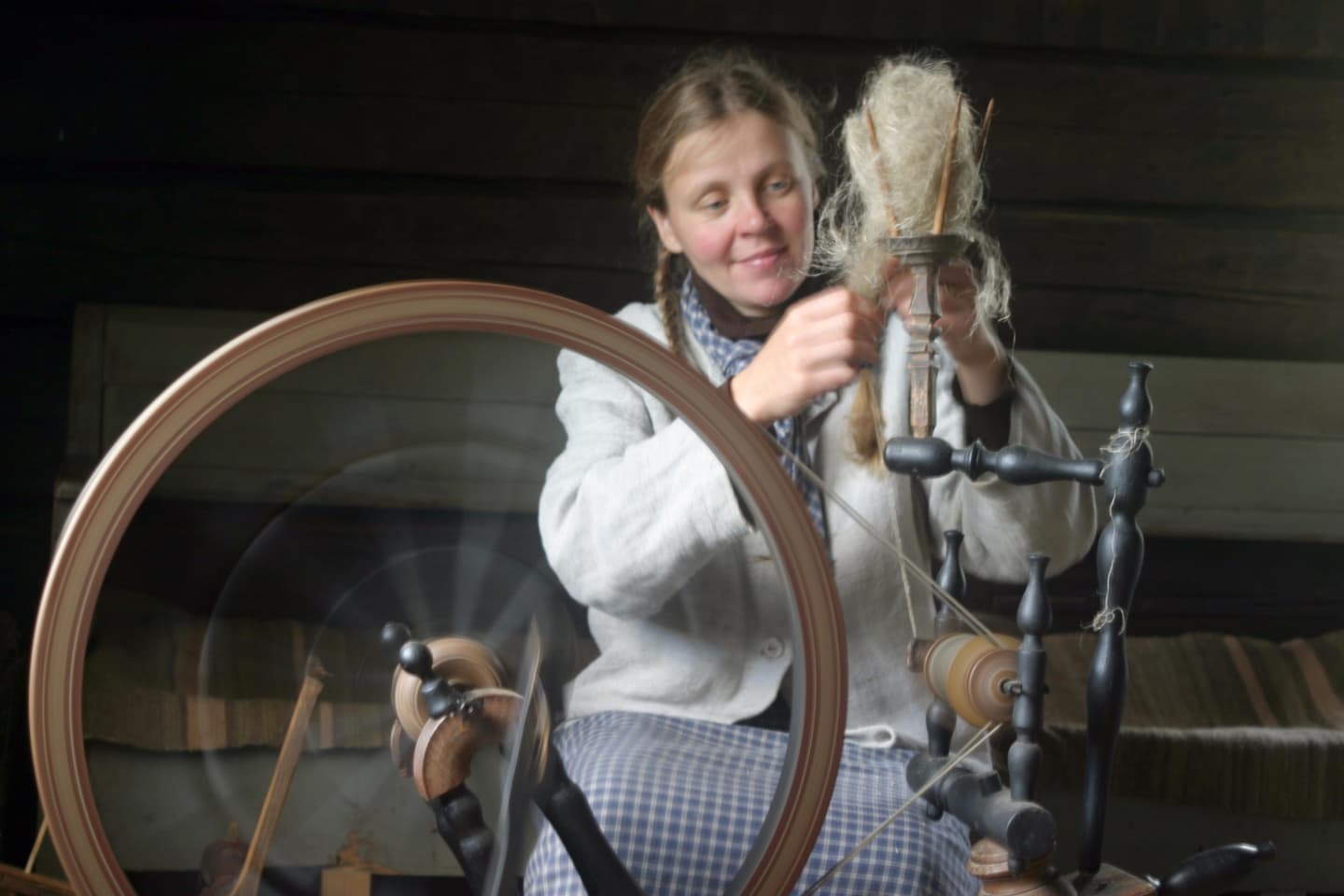 Kuva: Metsähallitus Nainen kehrää vanhalla rukilla.