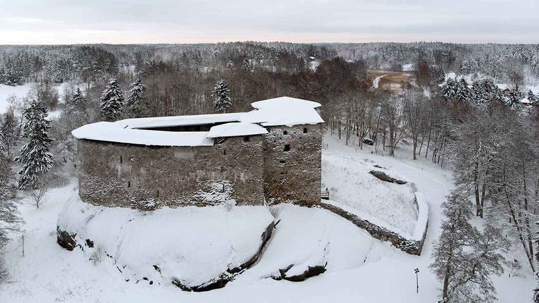 Ilmakuva Linnanrauniolta talvisin. Suuri vanha raunio, osittain katolla.