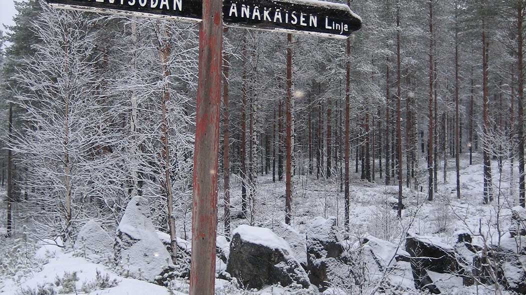 I en vägvisare texten Änäkäisen linja. I bakgrunden en vinterskog.